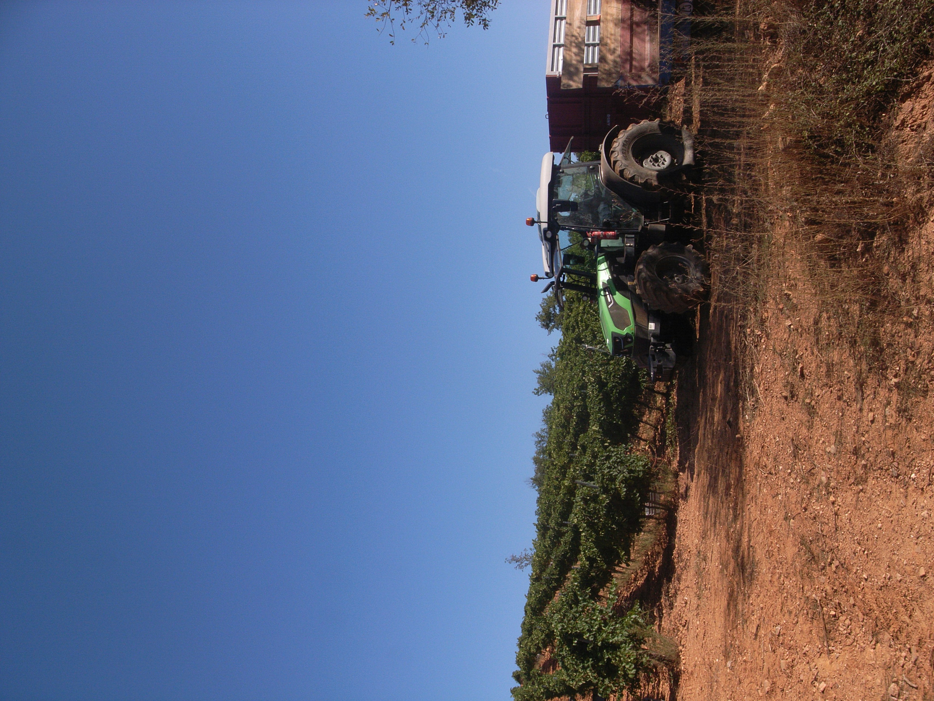 Tractor trabajando en una granja bajo un cielo azul despejado