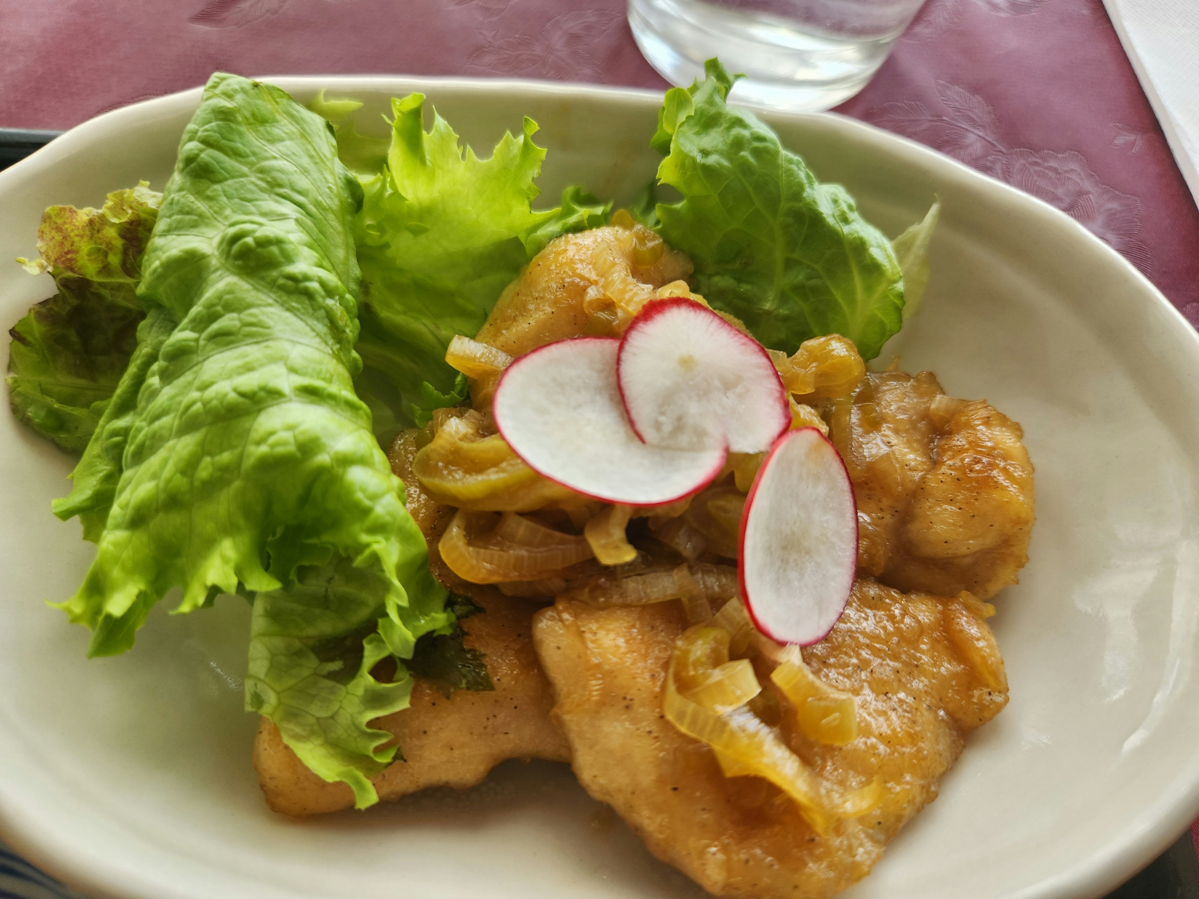 Piring ikan goreng disajikan dengan salad dan selada