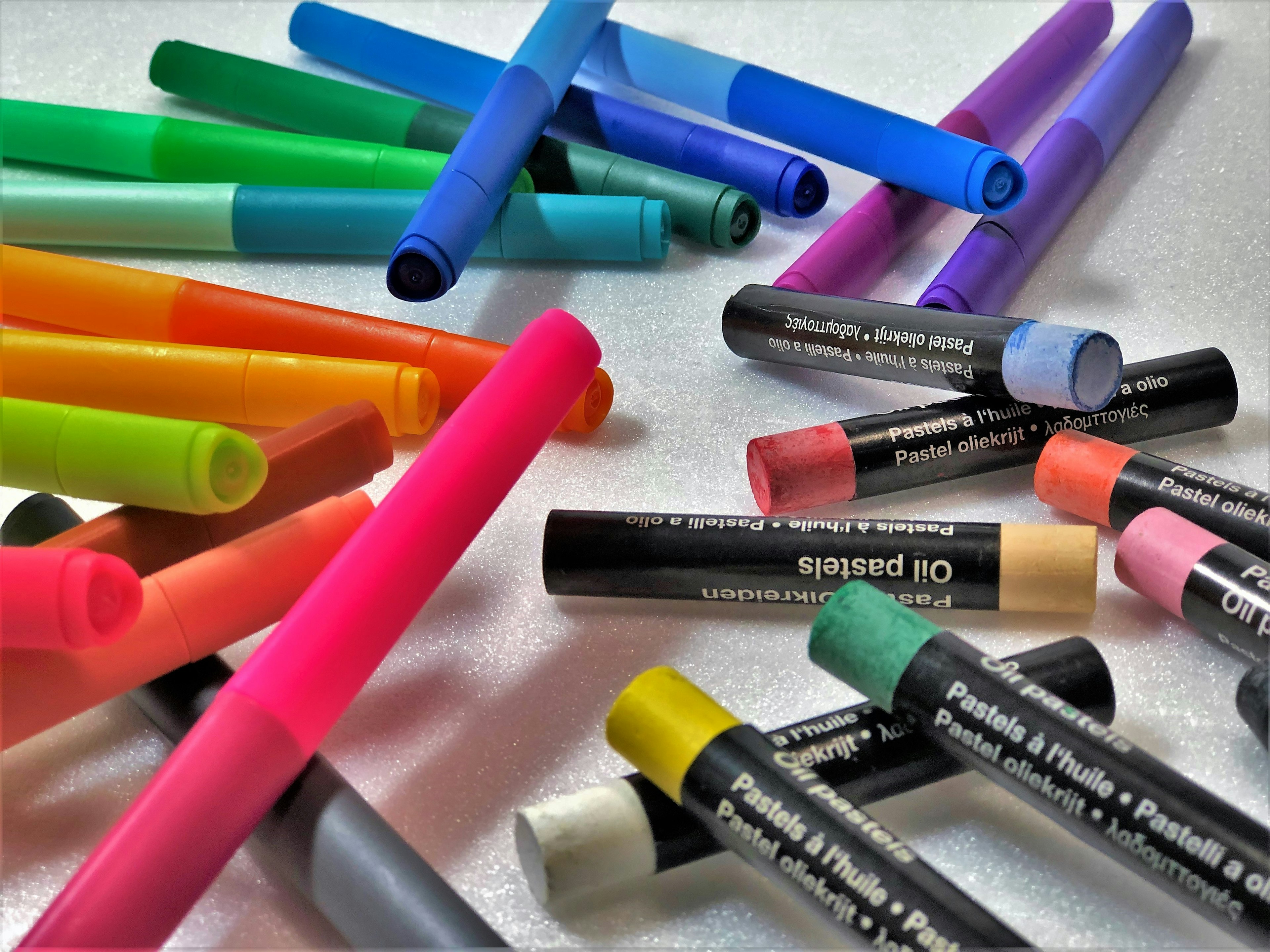 Colorful markers and crayons scattered on a surface