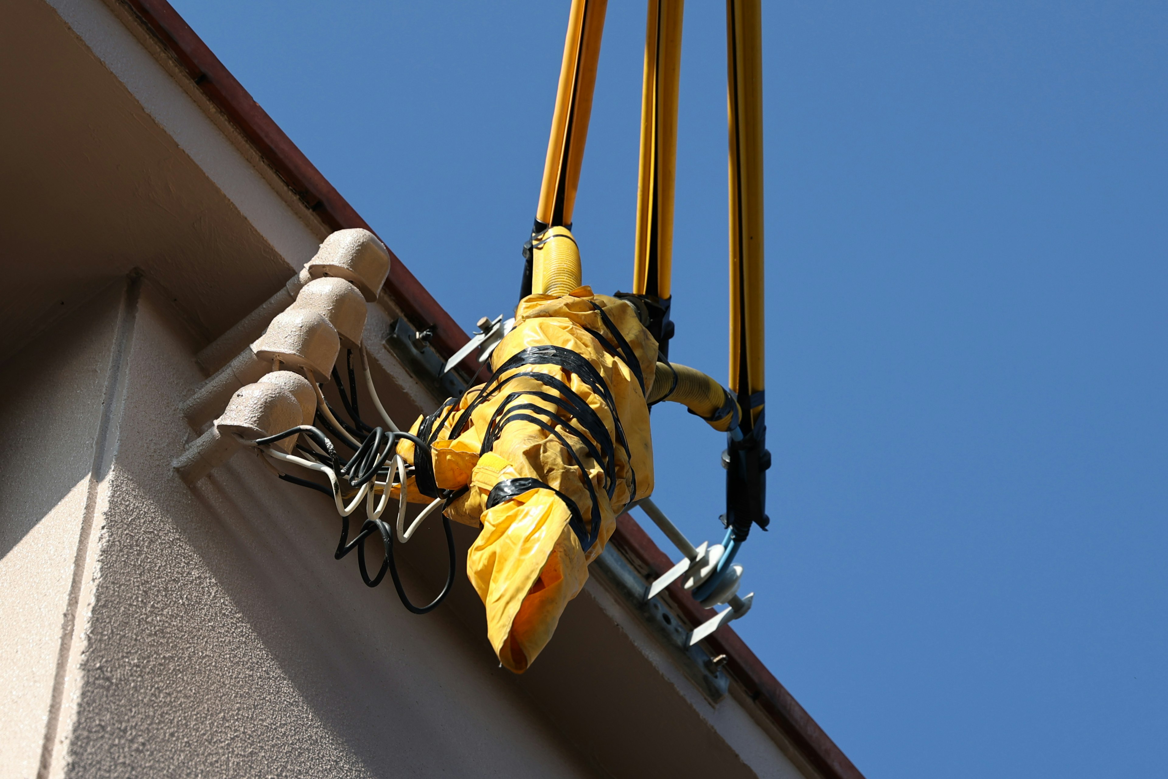 Équipement de grue jaune suspendu d'un bâtiment