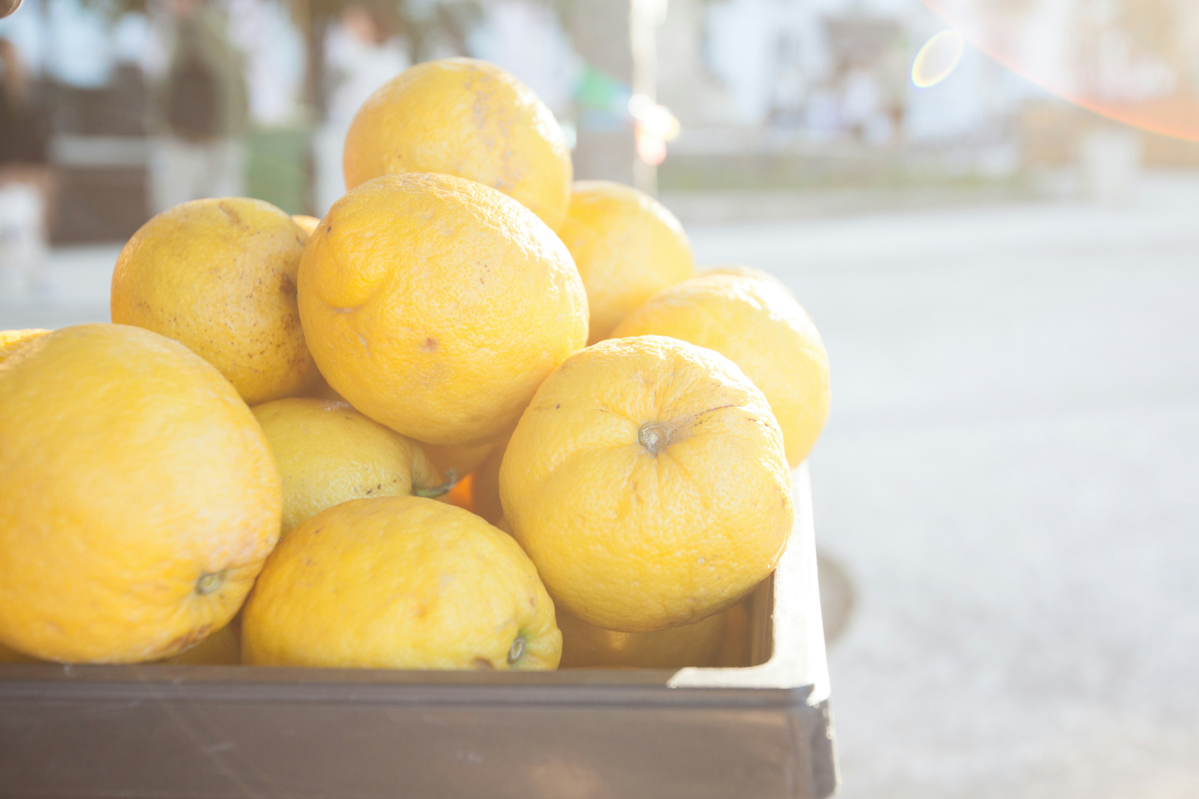 Una pila di limoni gialli brillanti alla luce del sole