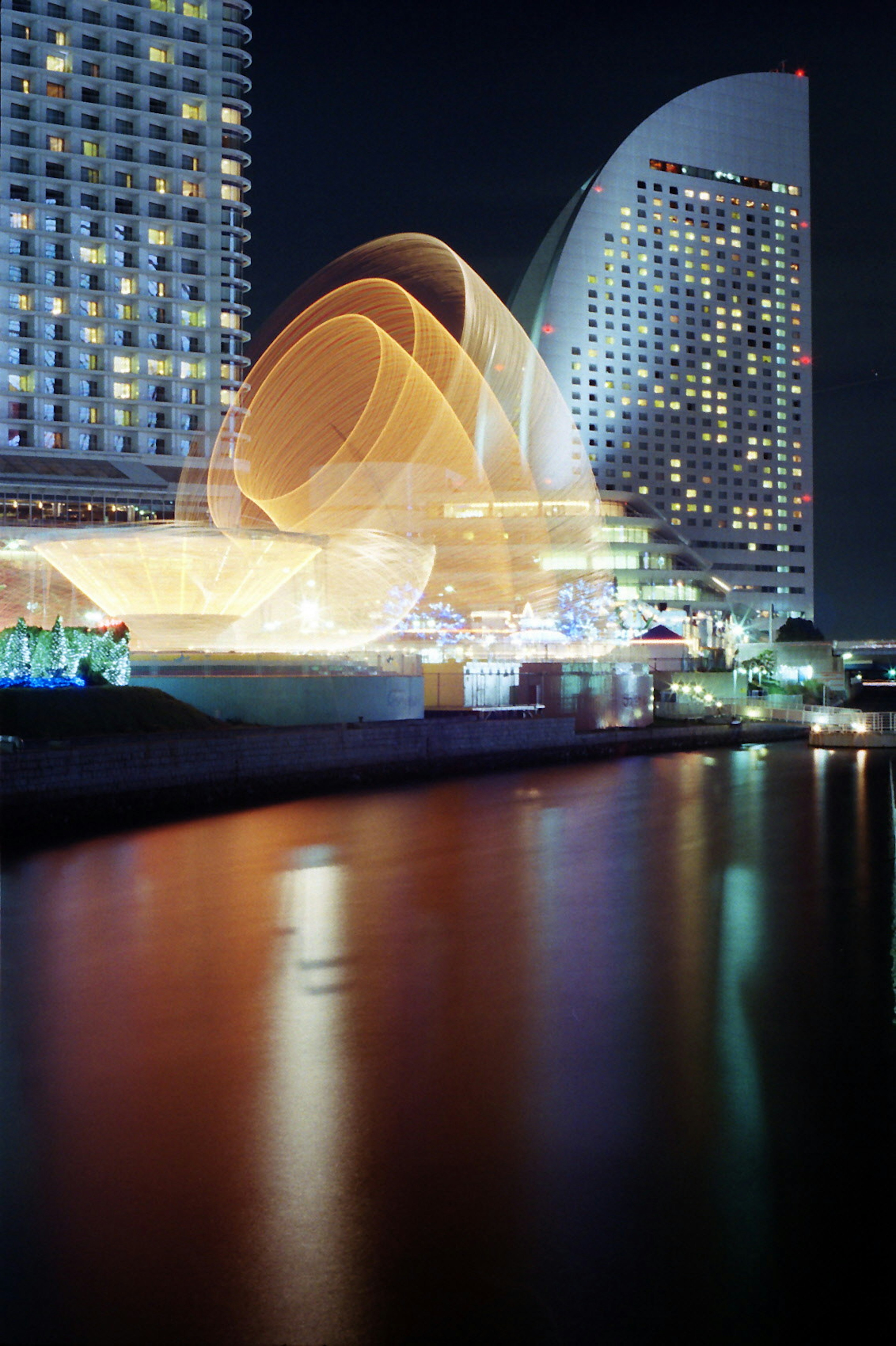 Modern buildings in Yokohama illuminated at night with reflections on the water