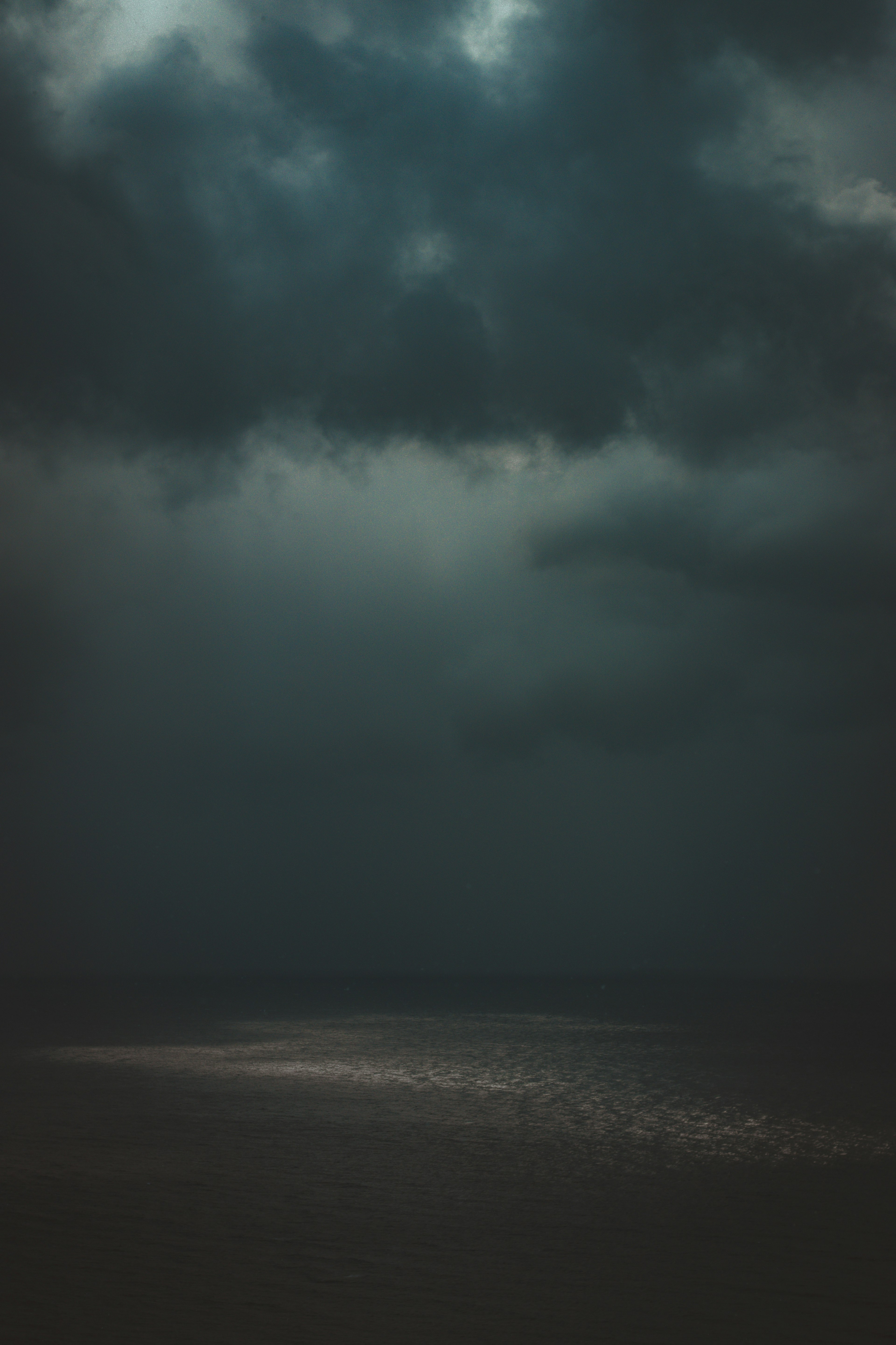 Dark clouds over a calm sea with subtle reflections