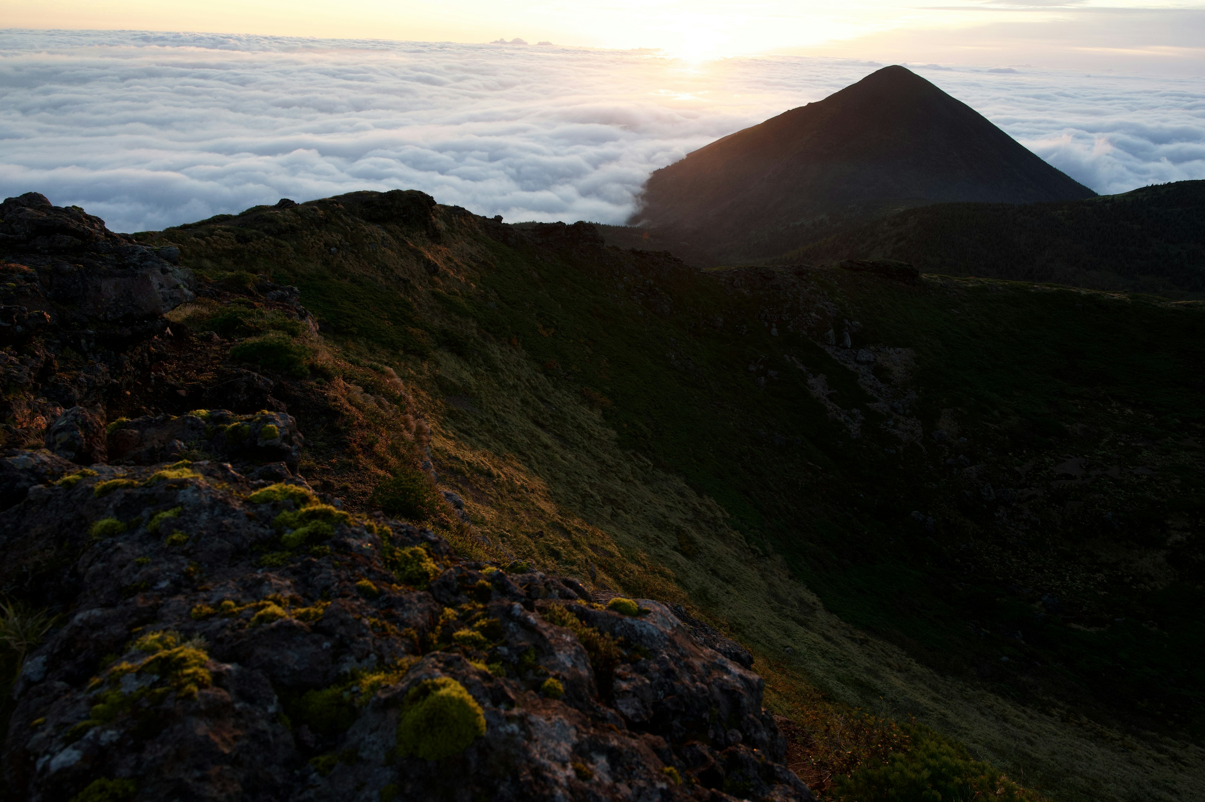 Silhouette di montagna sopra un mare di nuvole al tramonto