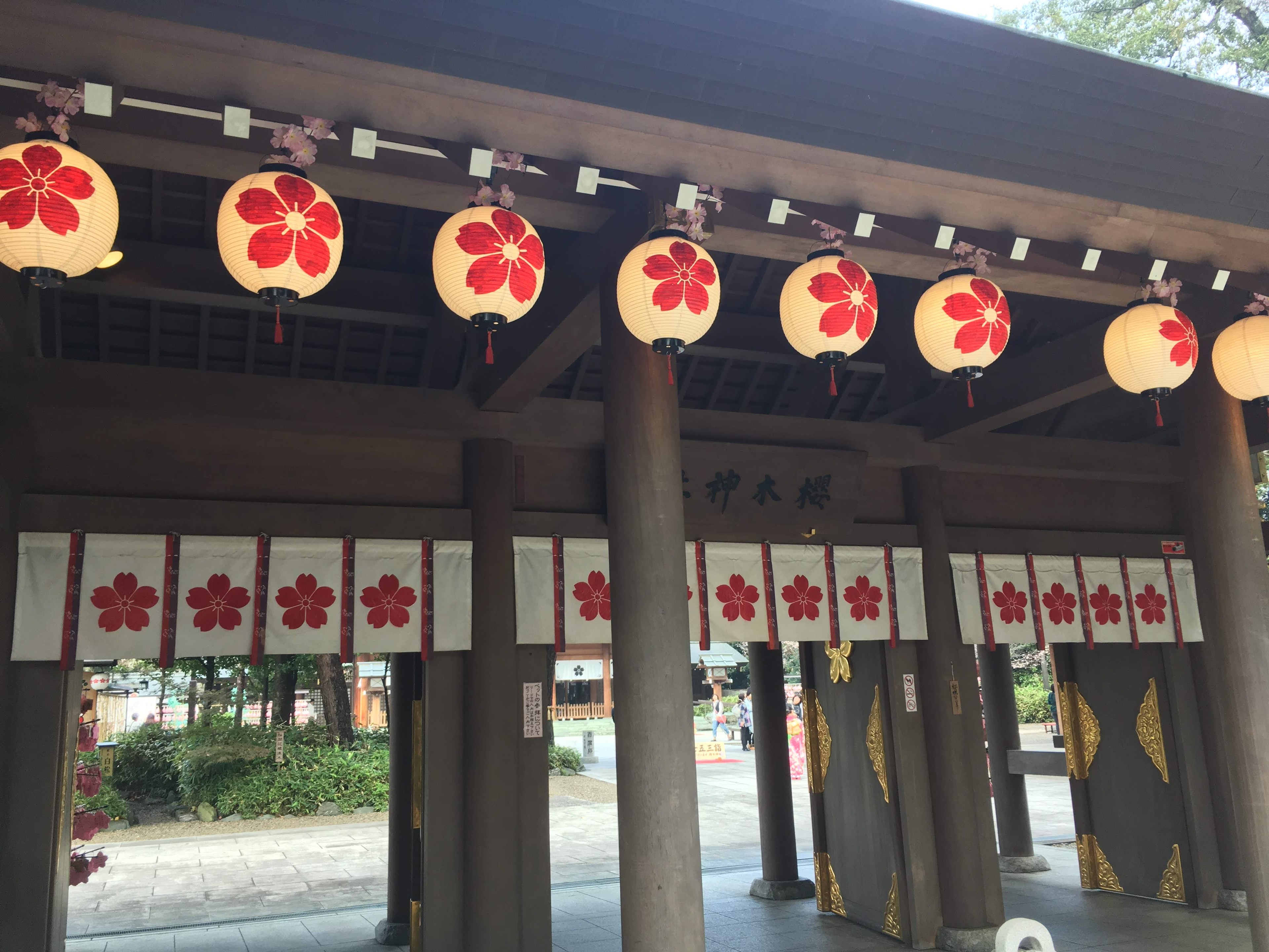 Entrée d'un bâtiment japonais traditionnel ornée de lanternes à motifs floraux rouges