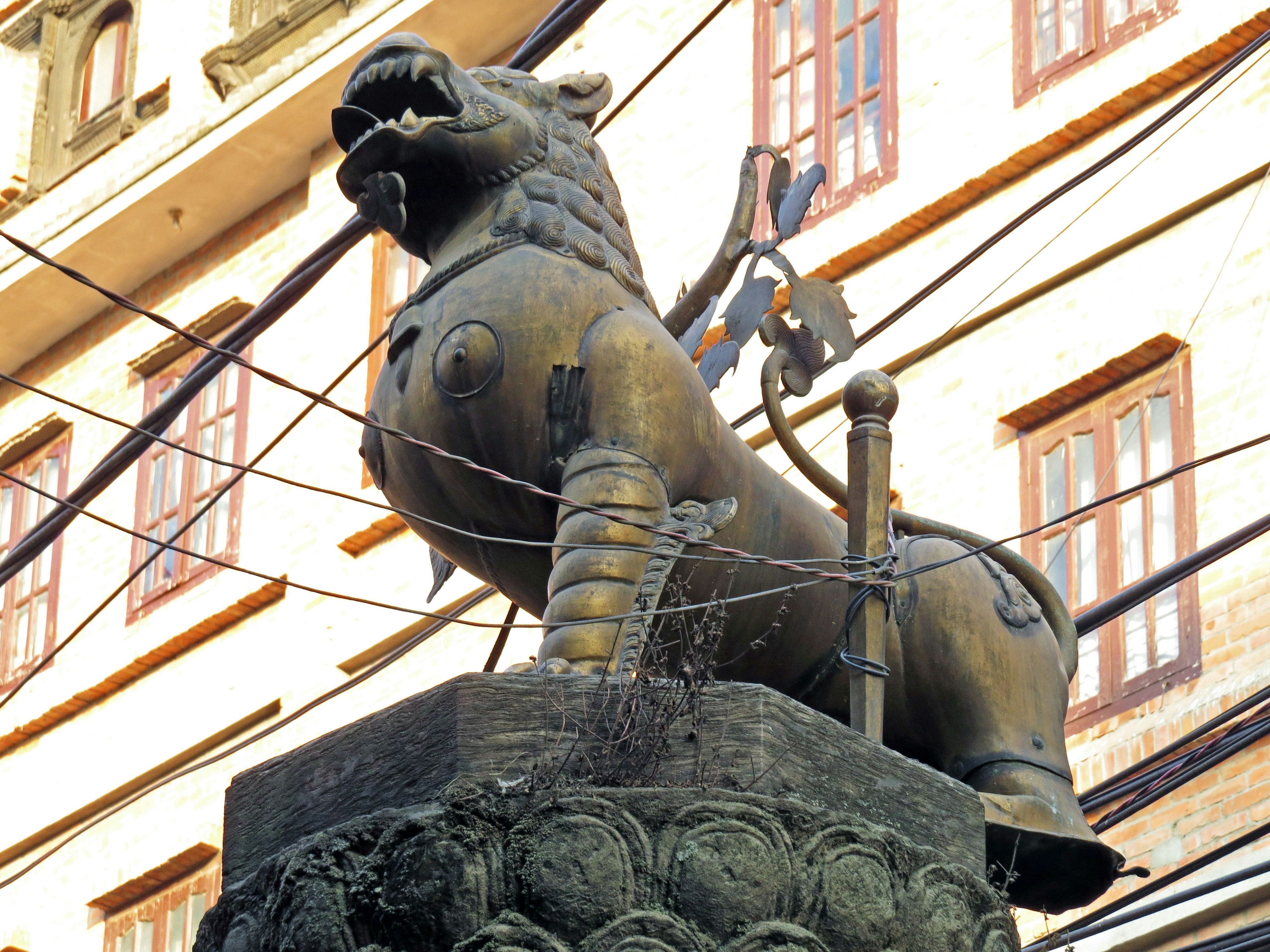 Estatua de león en la calle con fondo de edificio