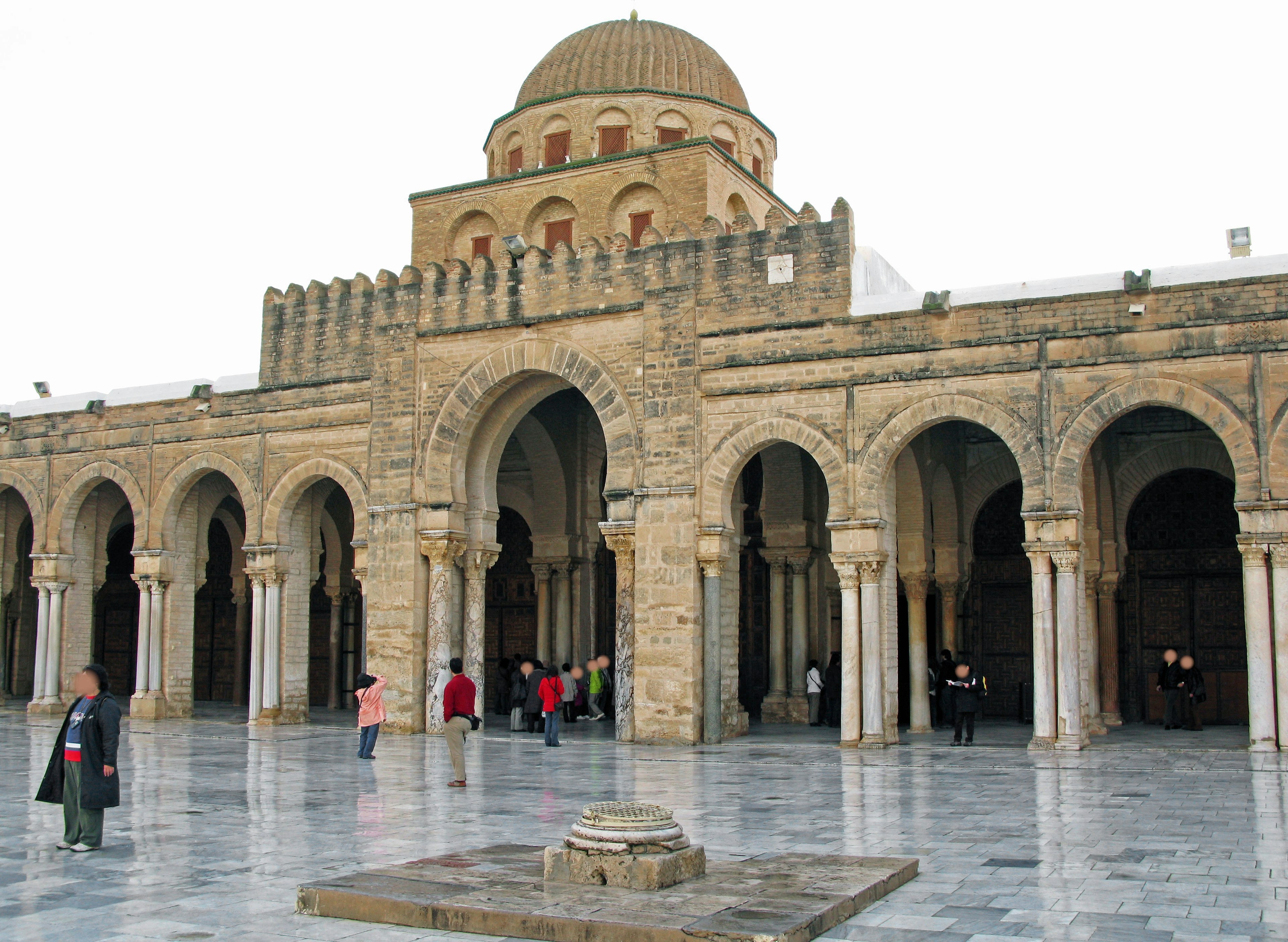 Bâtiment historique avec de grandes arches et un dôme Des gens se rassemblent dans la cour