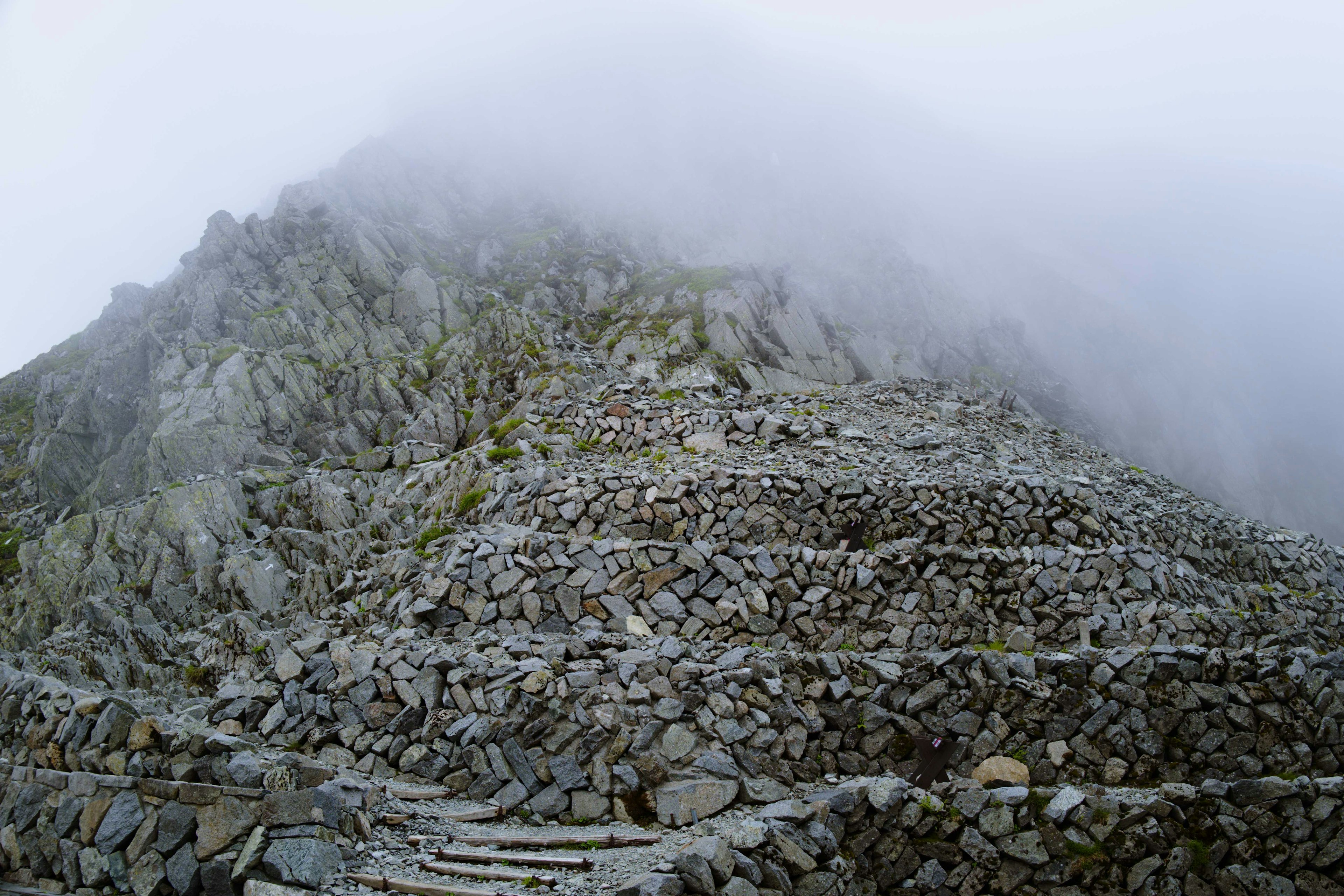 Escaliers rocheux couverts de brouillard menant à une montagne