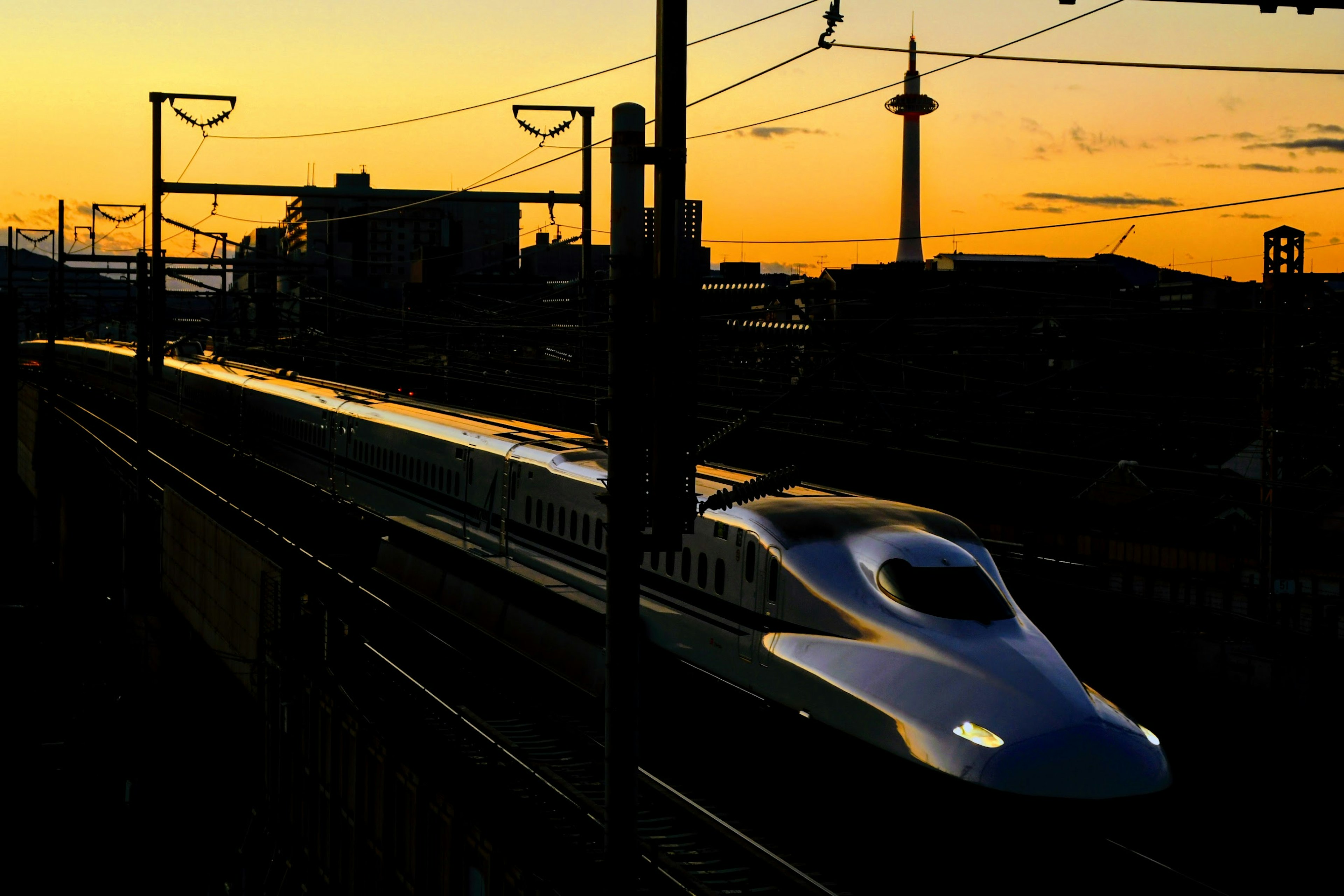 夕暮れに照らされた新幹線が駅に停車中