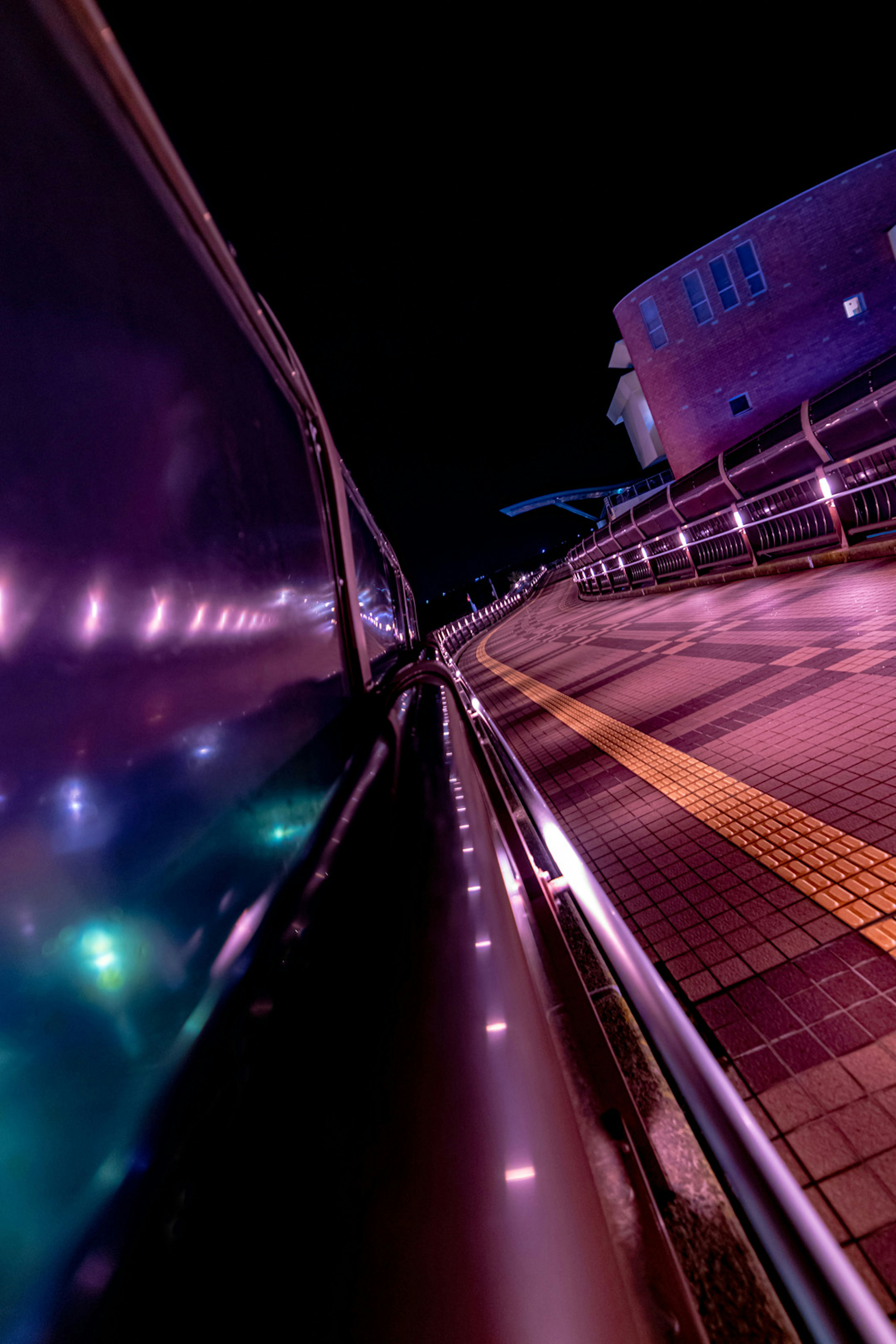 Côté de voiture reflétant les lumières violettes de la ville nocturne