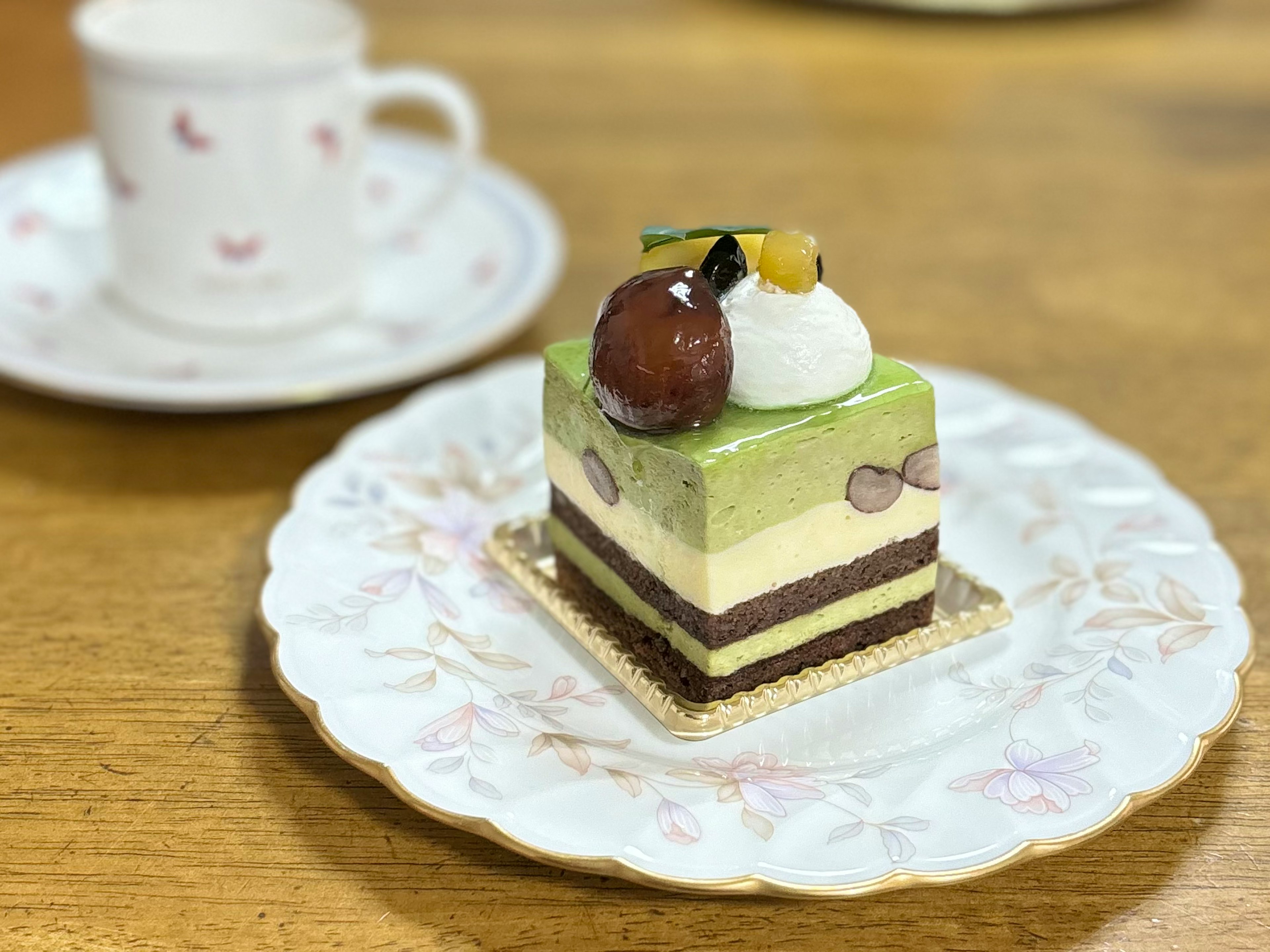 緑茶風味のケーキが飾られた白い皿の上に置かれたデザート