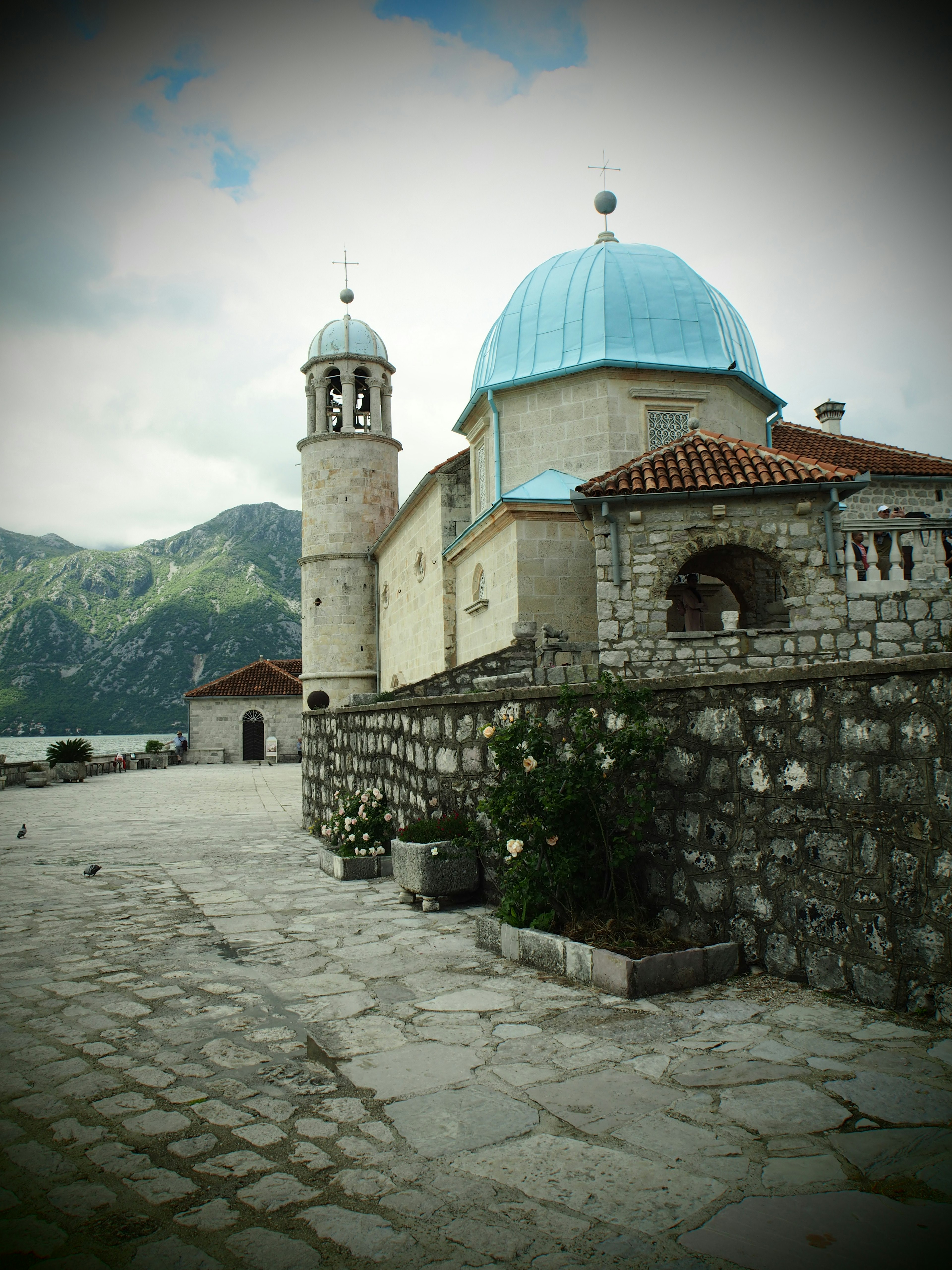 Vista panoramica con una chiesa con cupola blu e edifici in pietra