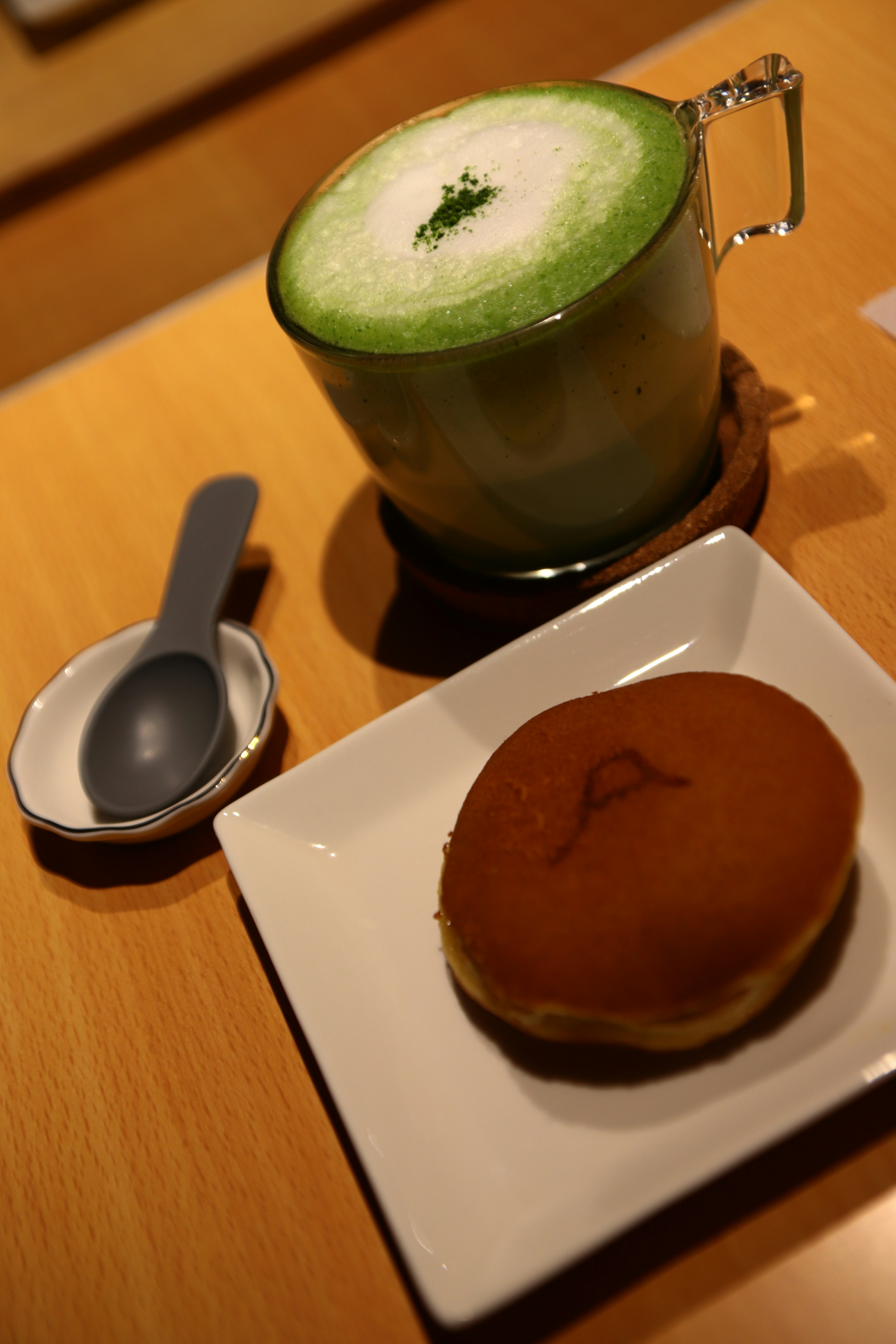 Latte matcha dan manisan Jepang di atas piring