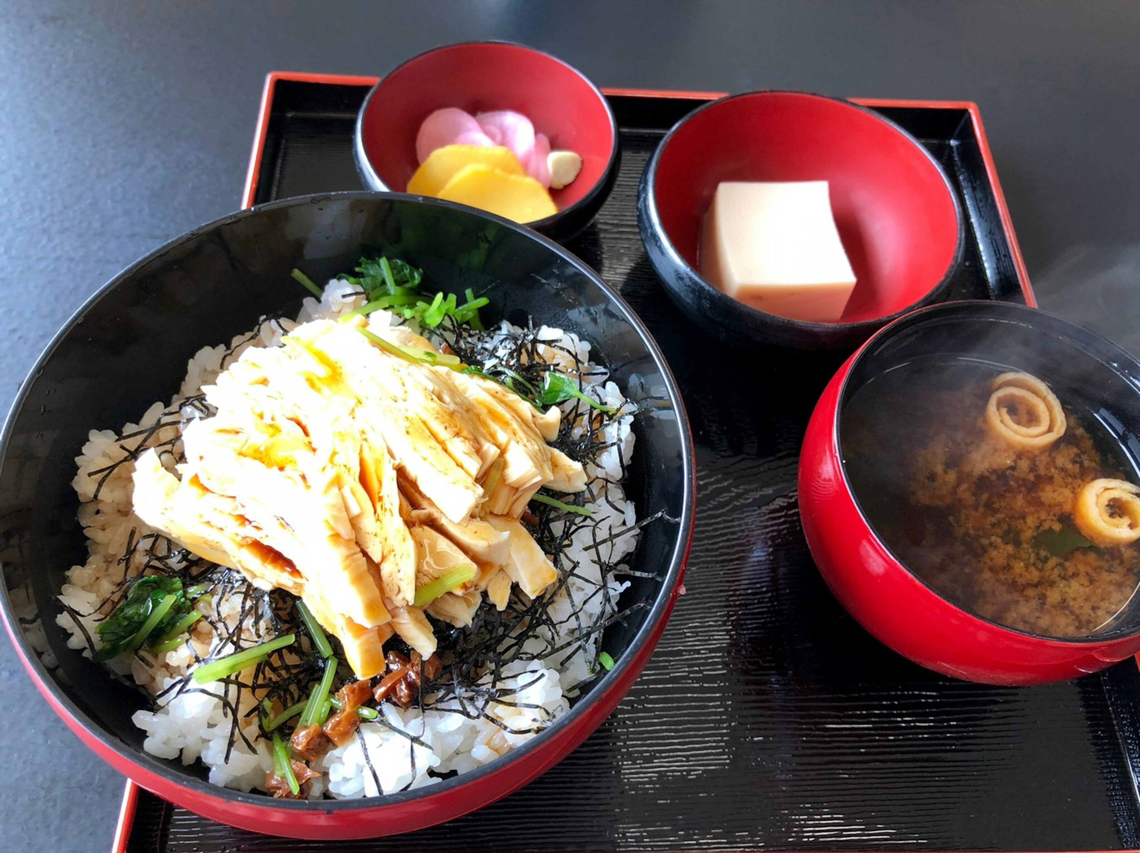 Un conjunto de comida japonesa lujosa con arroz cubierto de huevo y alga