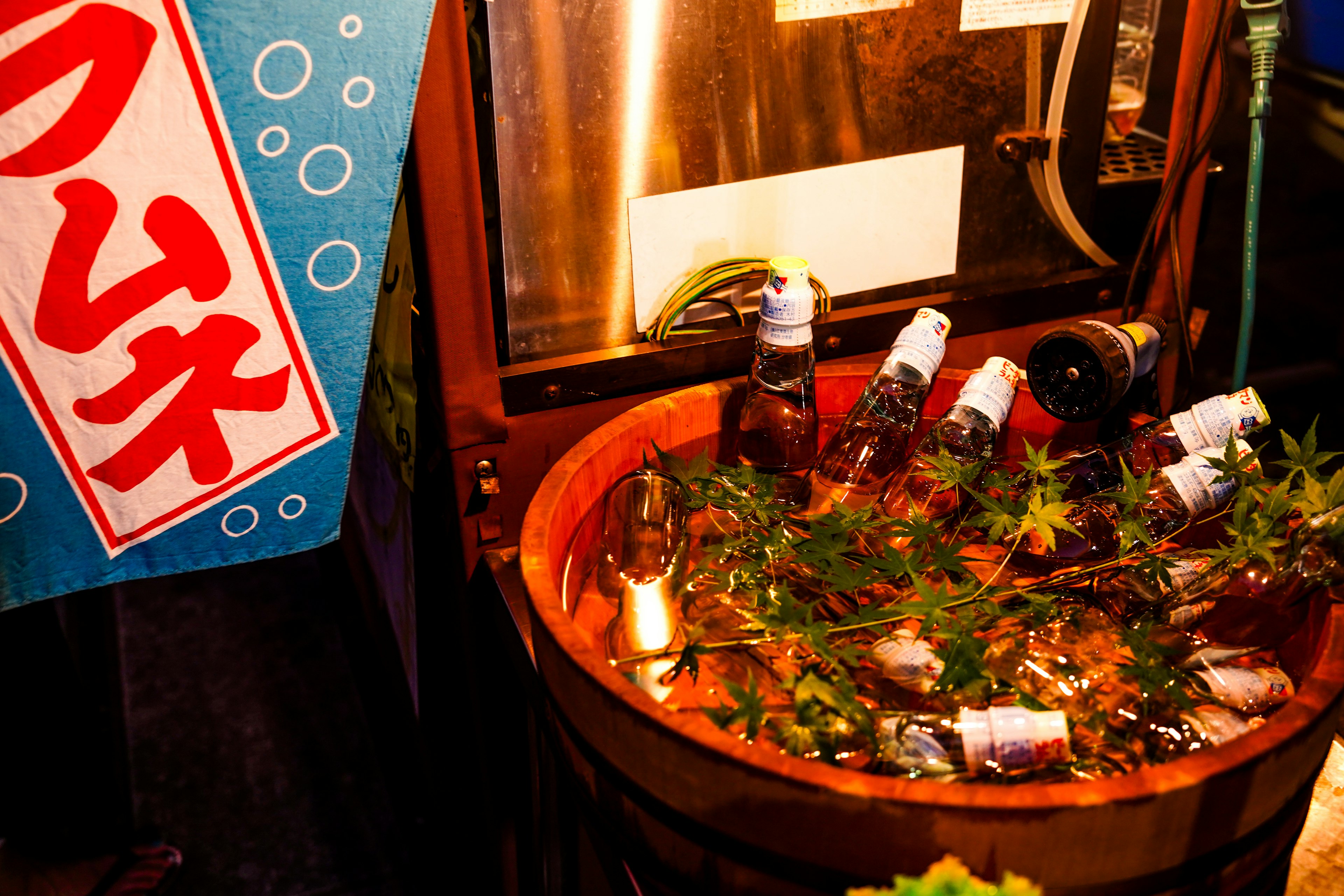 Bac en bois rempli de glace et de bouteilles de bière dans un stand de rue