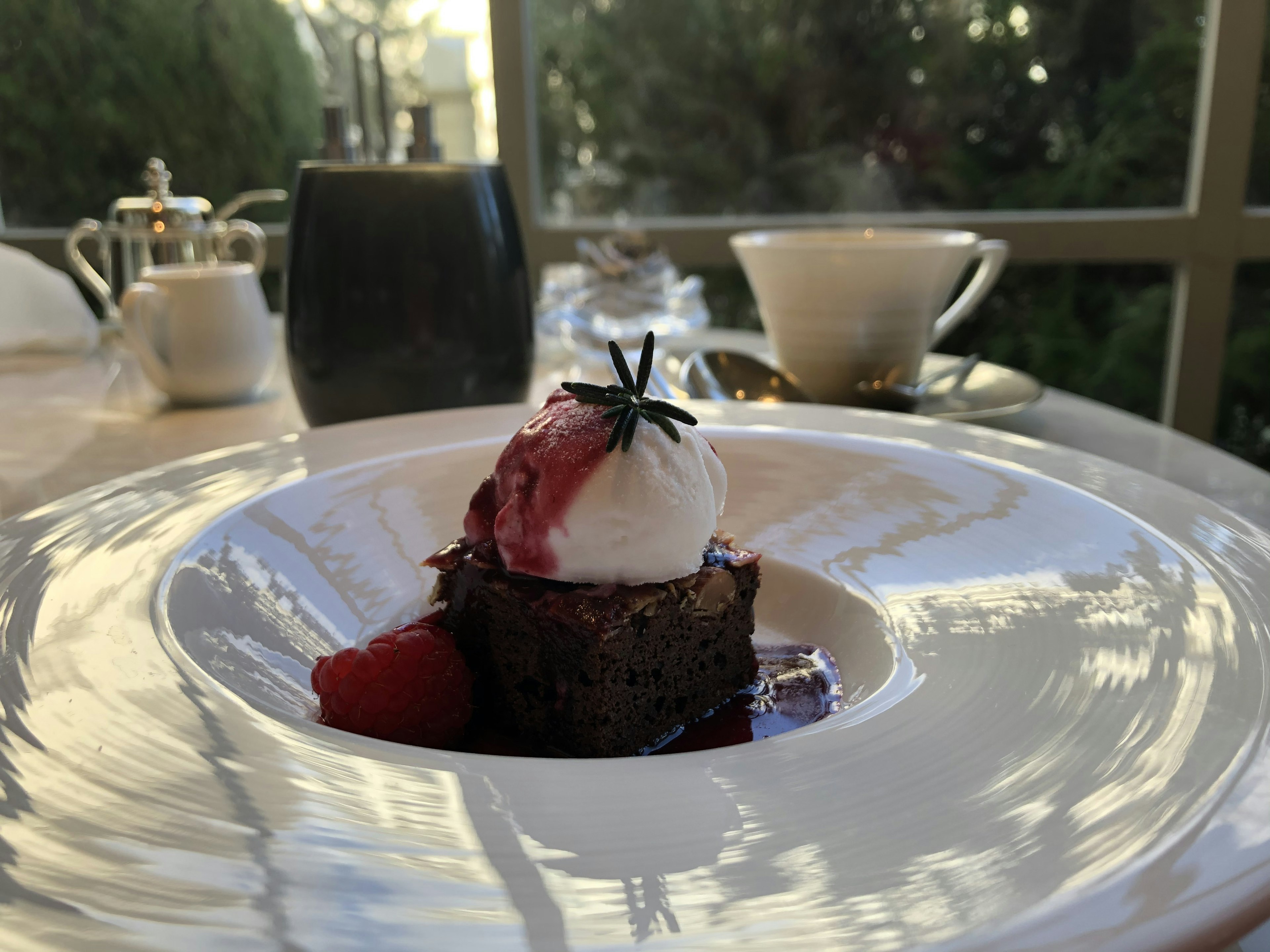 Chocolate cake with ice cream and raspberry sauce on a white plate