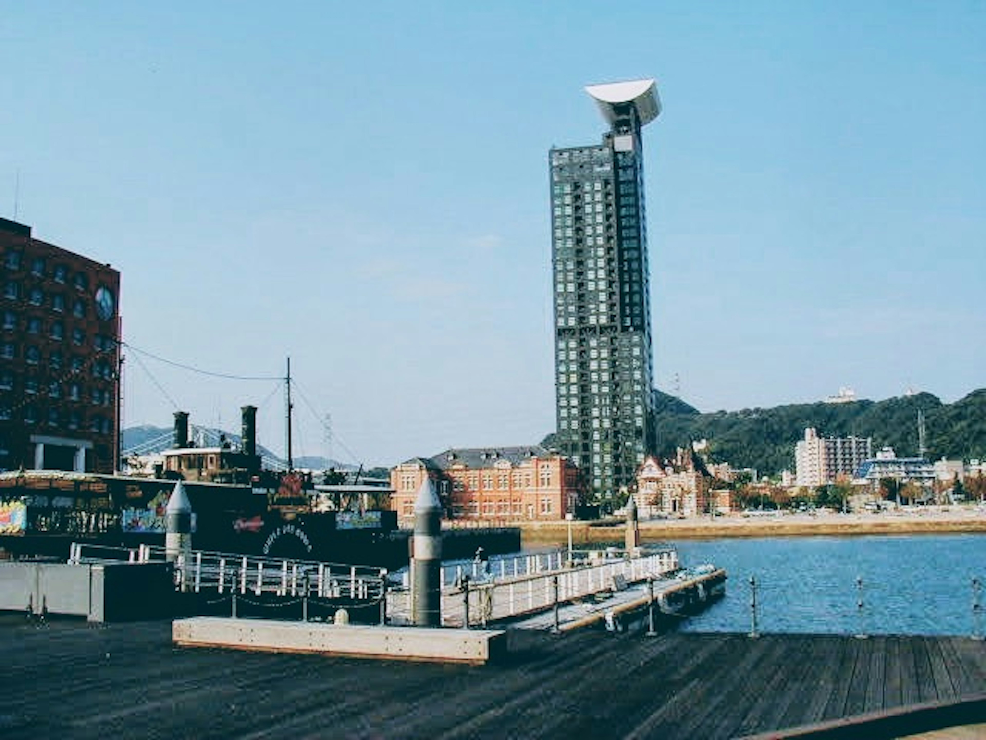 View of a docked ship and a tall building by the harbor