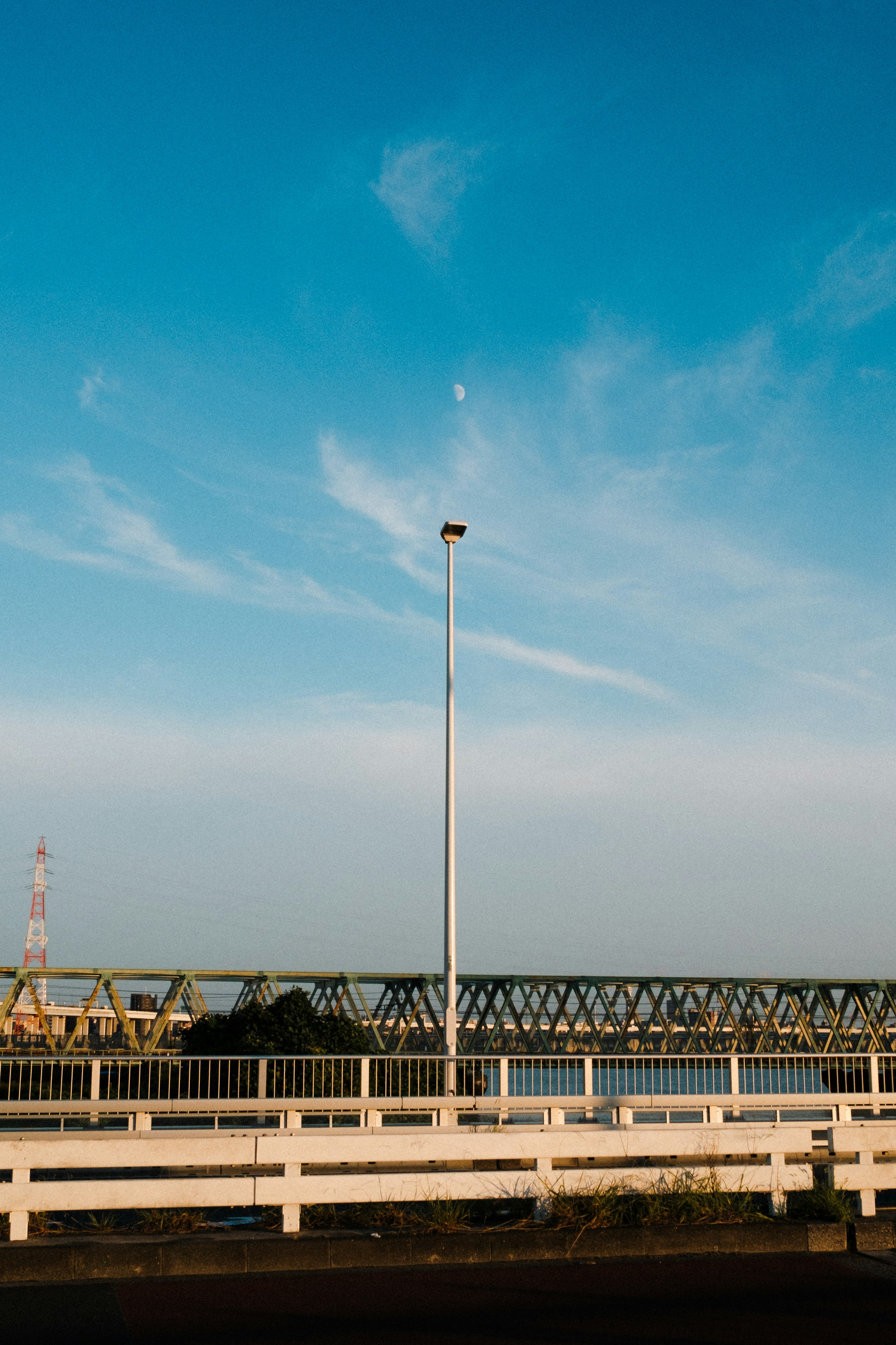 Pemandangan dengan jembatan dan lampu jalan di bawah langit biru