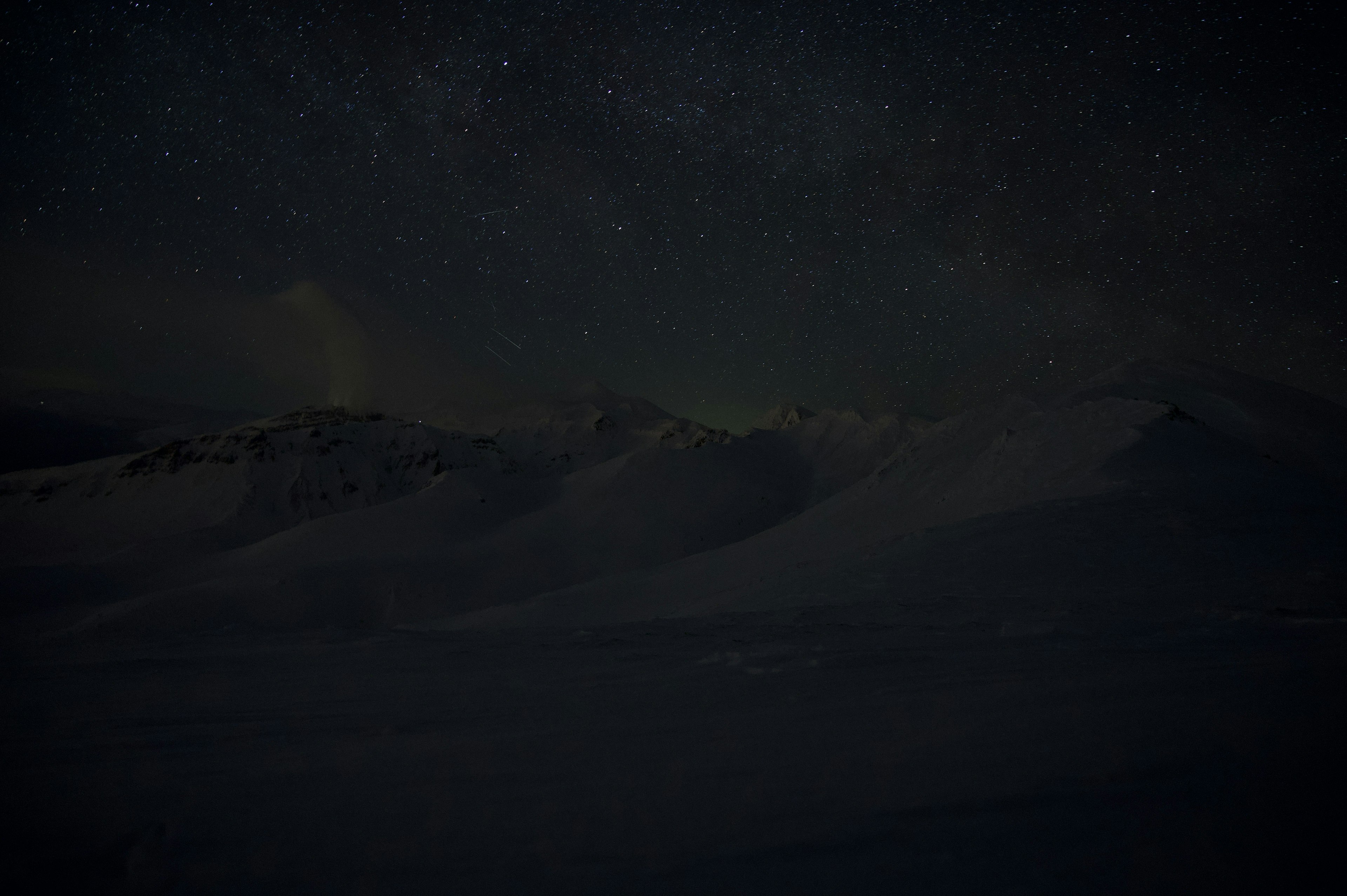 星空に覆われた暗い山々の風景