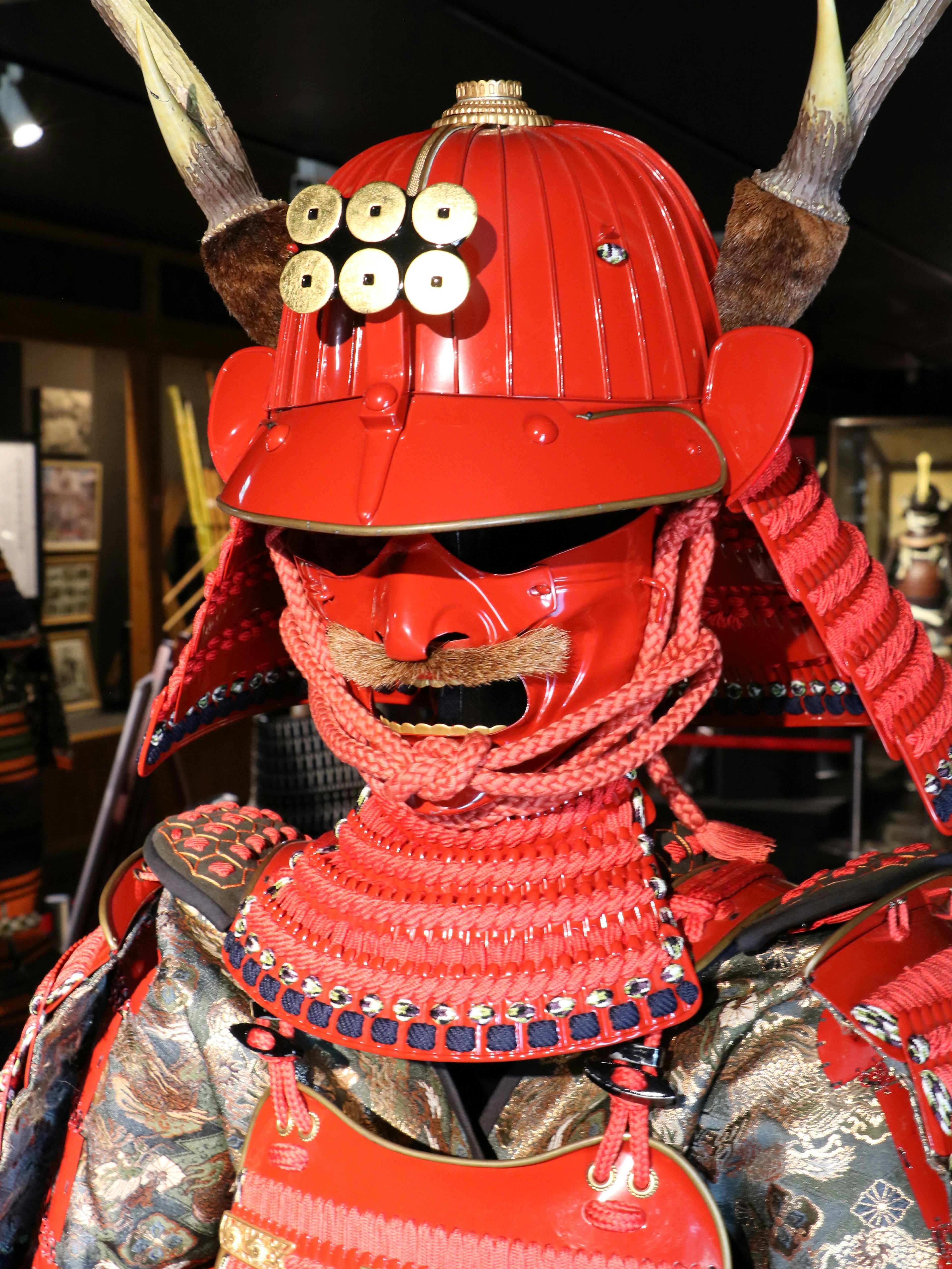 Samurai armor in vibrant red color featuring distinctive horns and intricate details