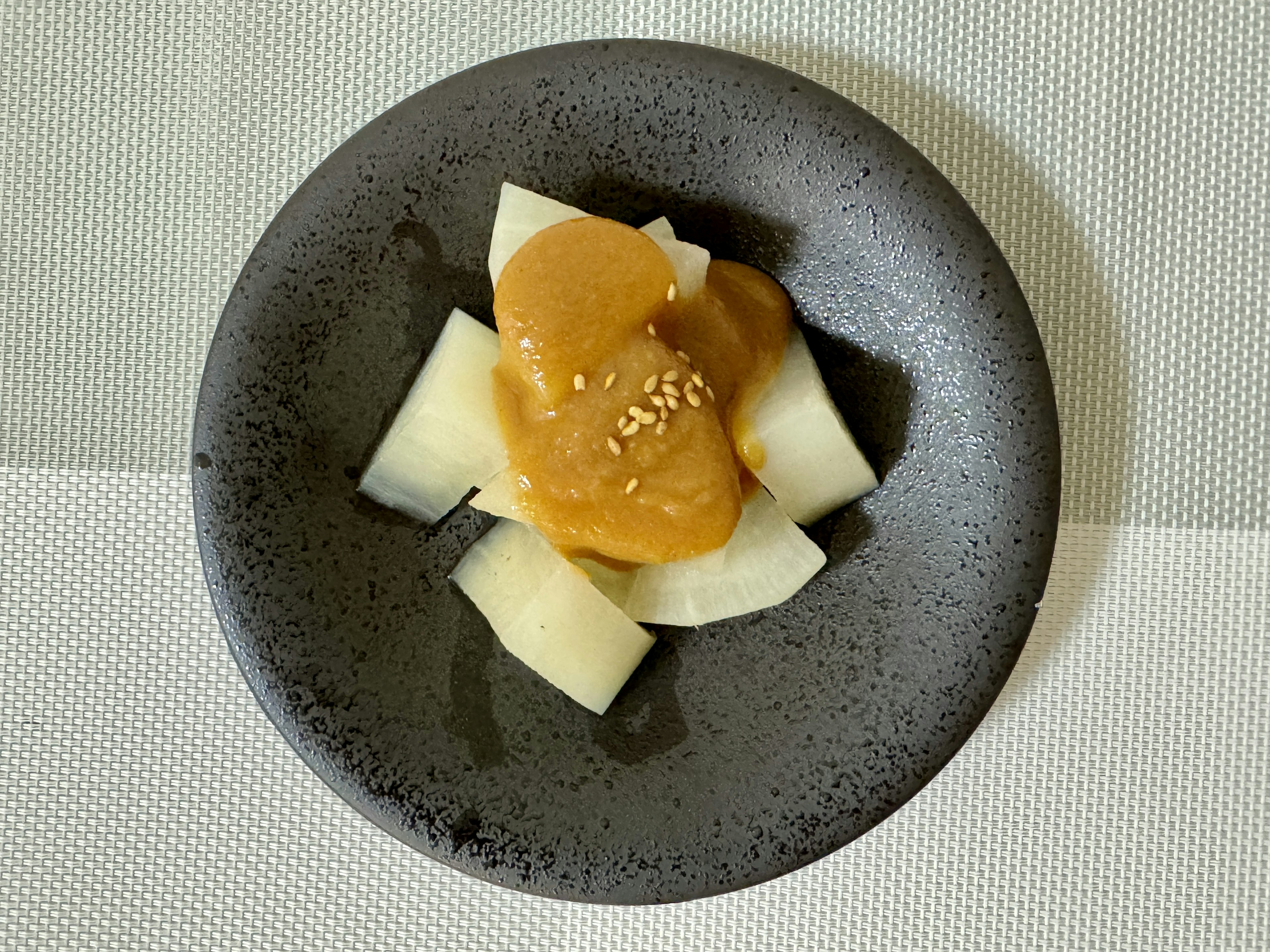 Dessert de morceaux de fruit blanc avec une pâte sucrée sur une assiette noire