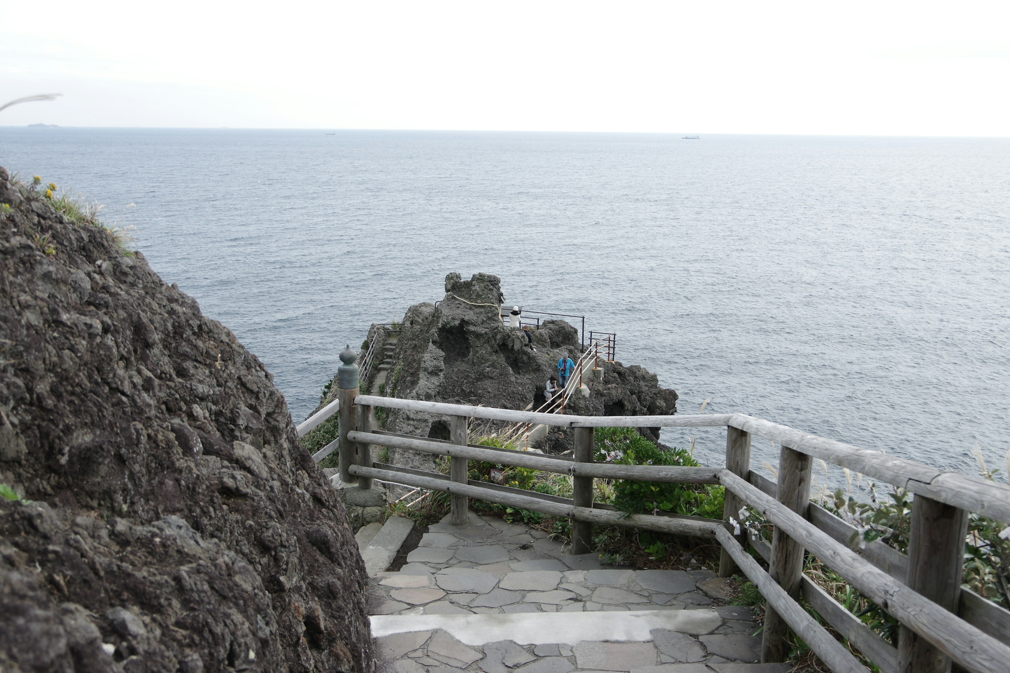 海を見渡す石の階段と木の手すりがある風景