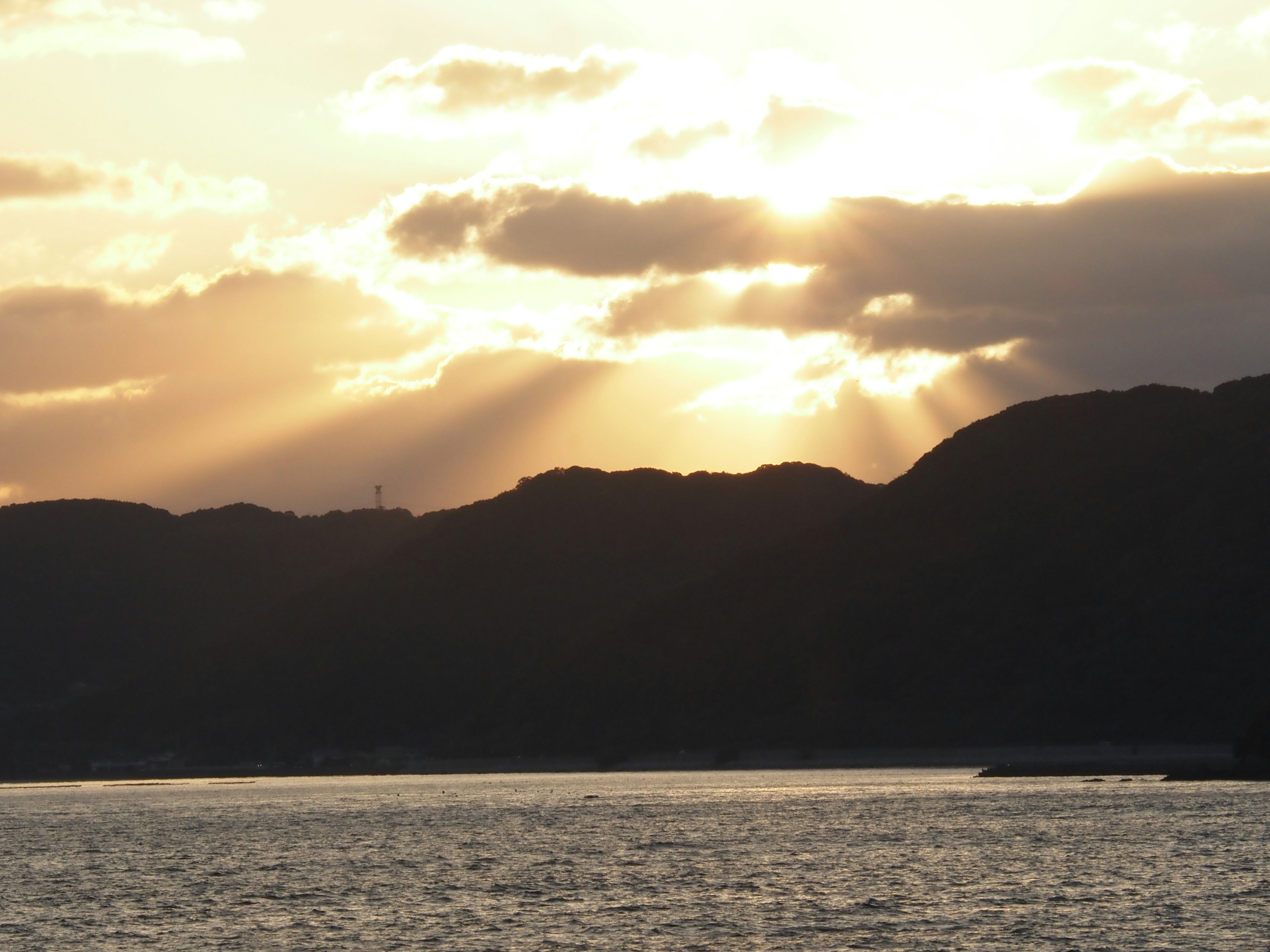 Bellissimo paesaggio con raggi di sole al tramonto che filtrano tra le nuvole