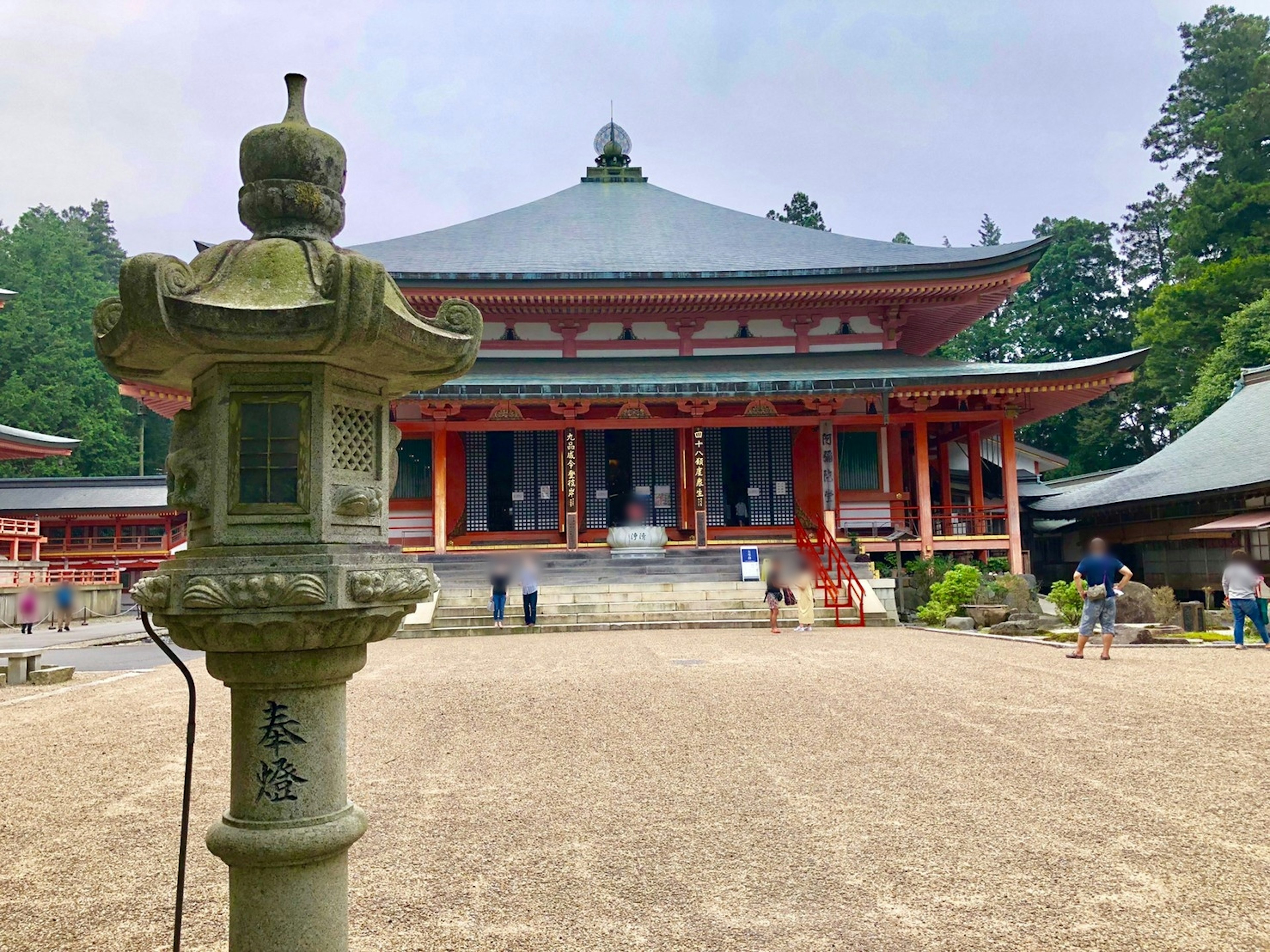 美しい寺院の前に立つ石灯籠 緑豊かな木々に囲まれた神社の景色