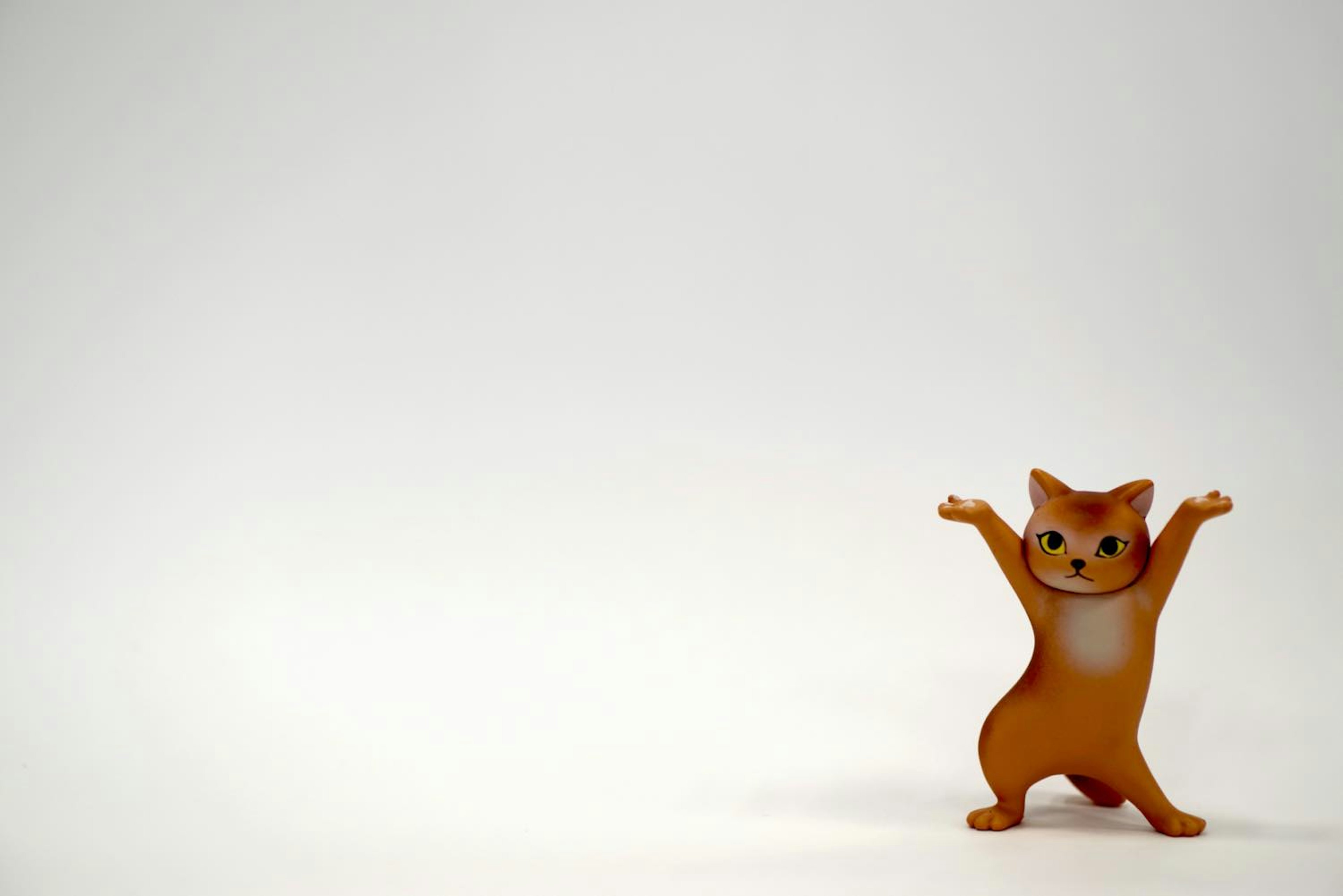 Una figura de gato naranja con los brazos levantados