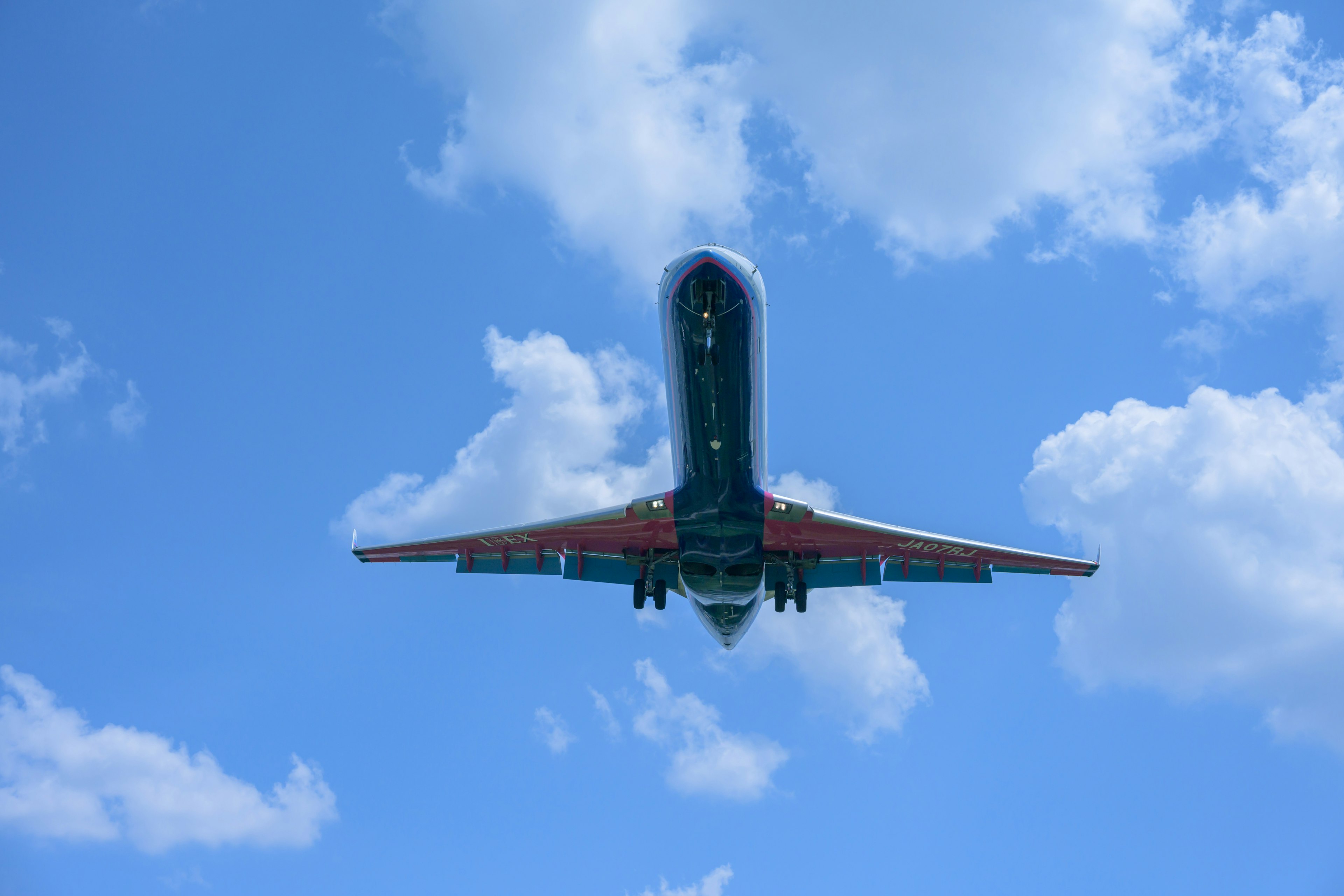 Passenger airplane viewed from below against a clear blue sky