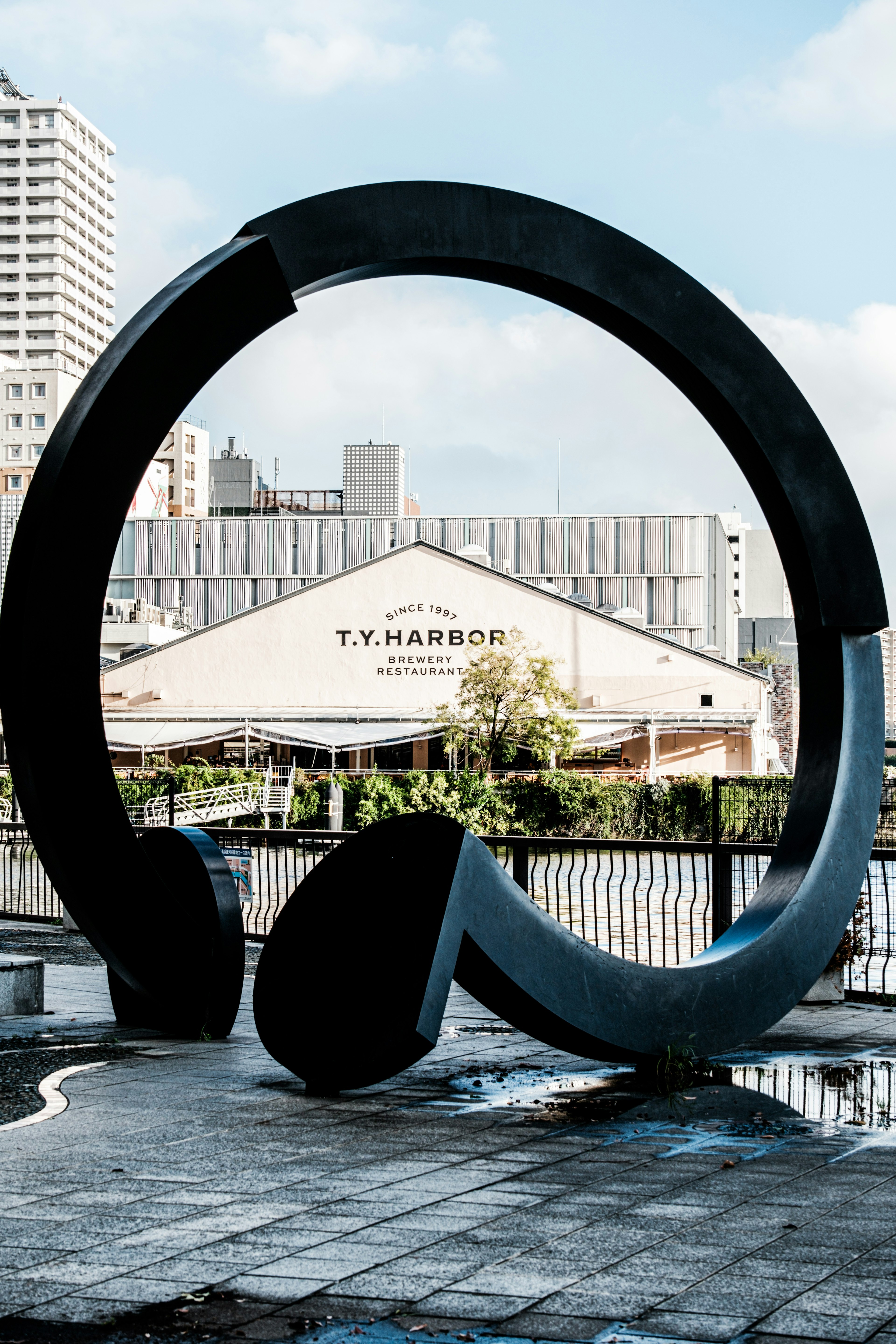 Escultura de grandes auriculares con el edificio T.M. Harbor al fondo