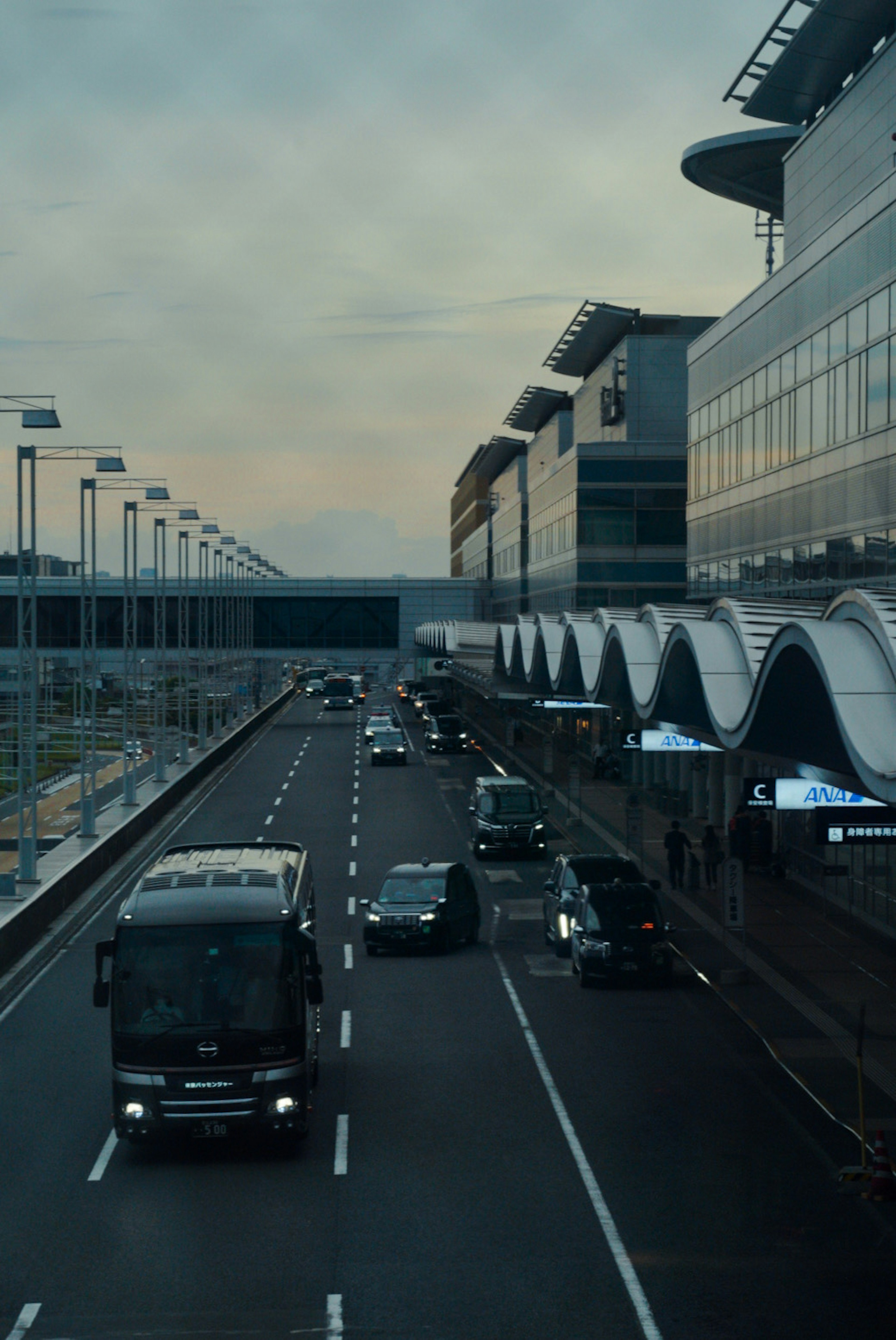 空港の道路に沿った車両と近代的な建物の風景