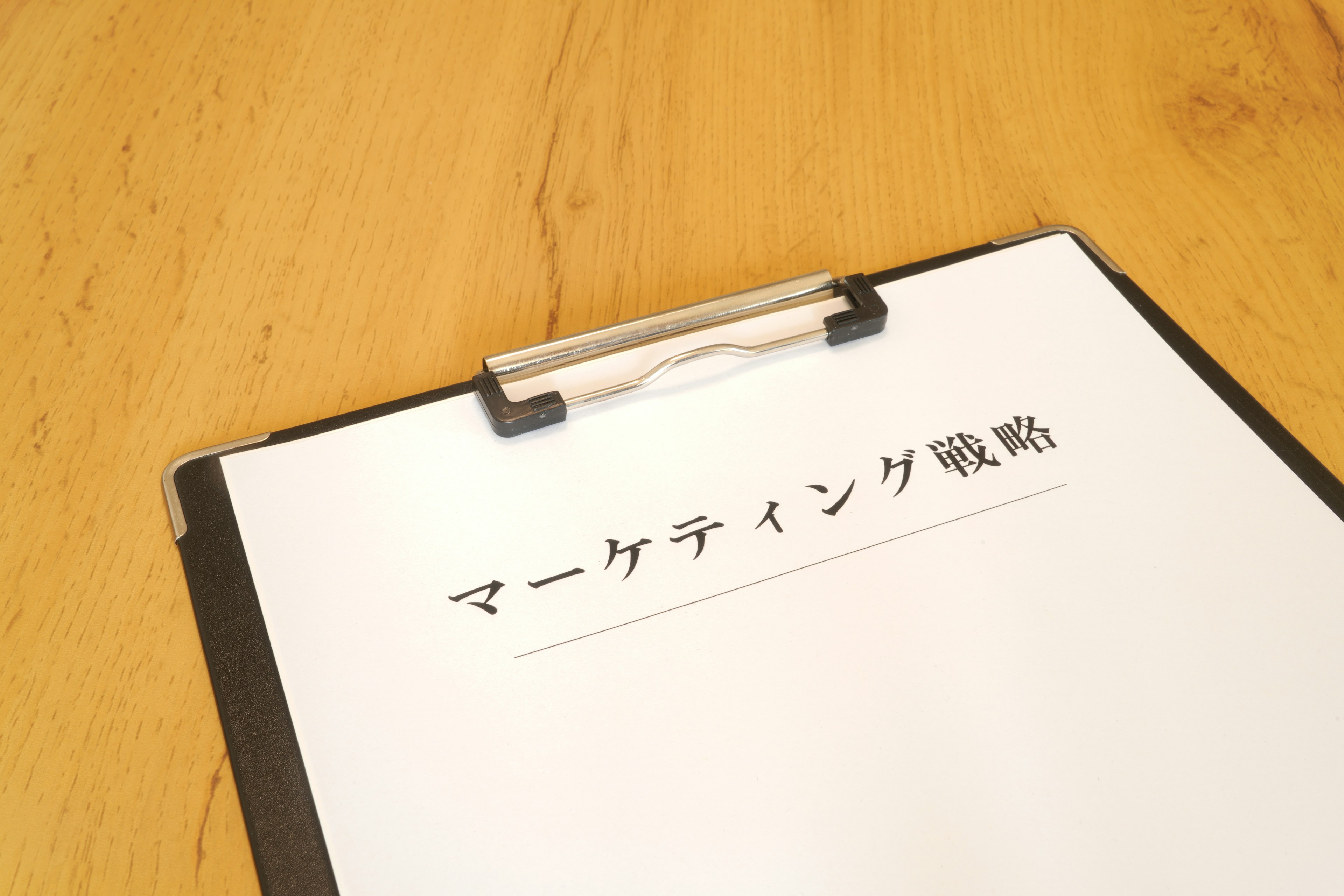 Clipboard with marketing strategy text on a wooden table