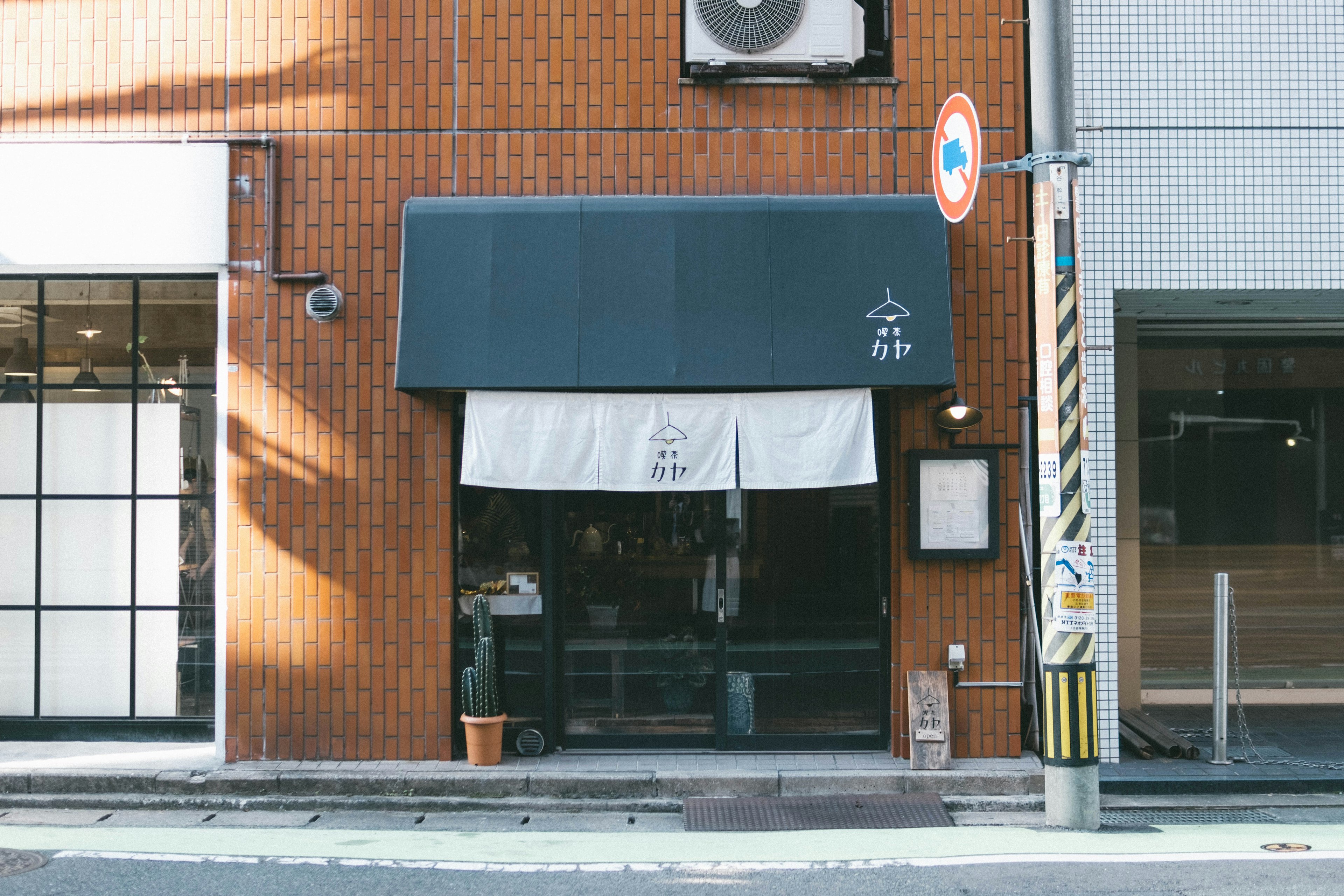 Traditional Japanese shop with brown brick wall blue awning and white noren curtain