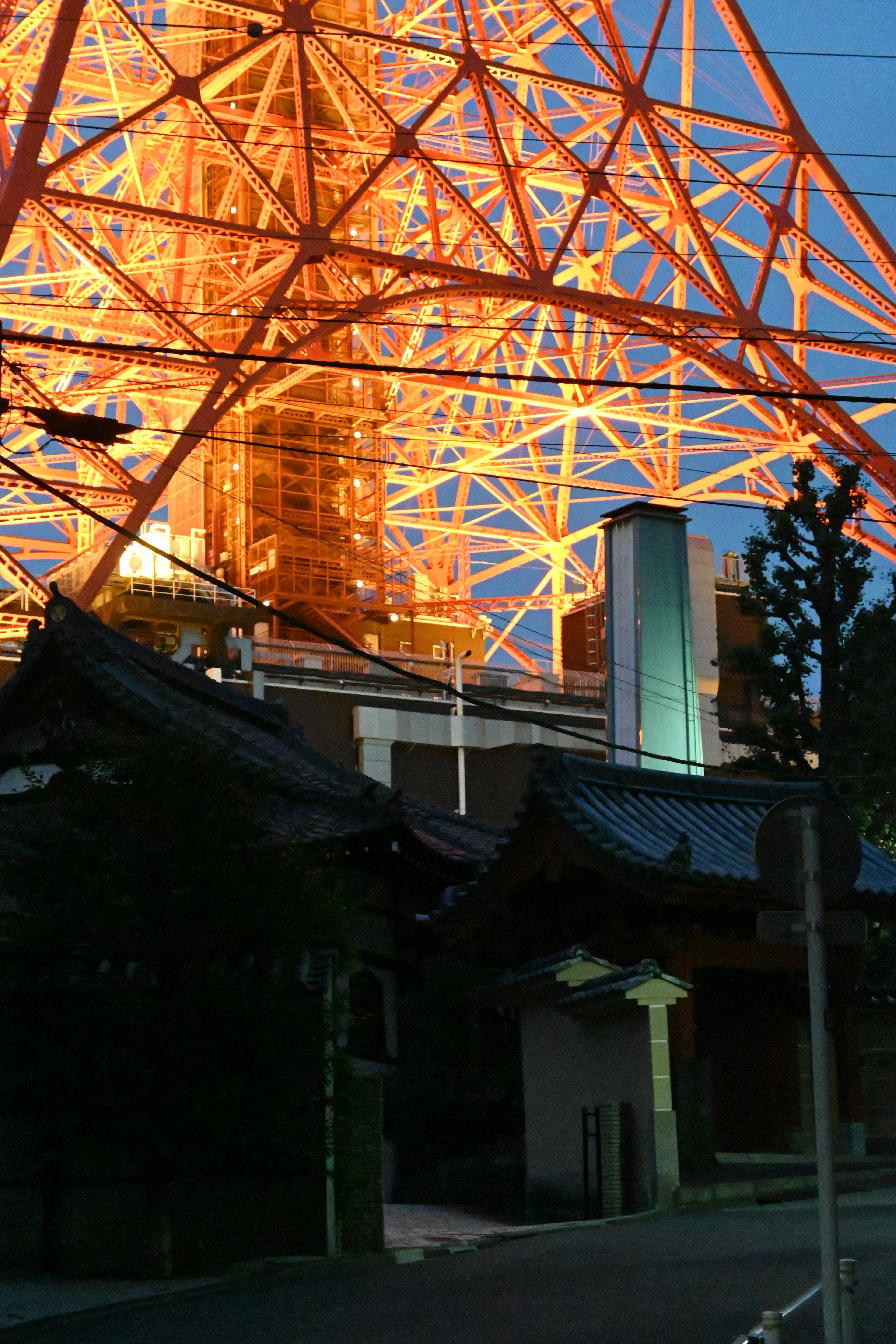 Tokyo Tower illuminated at night with traditional building in foreground