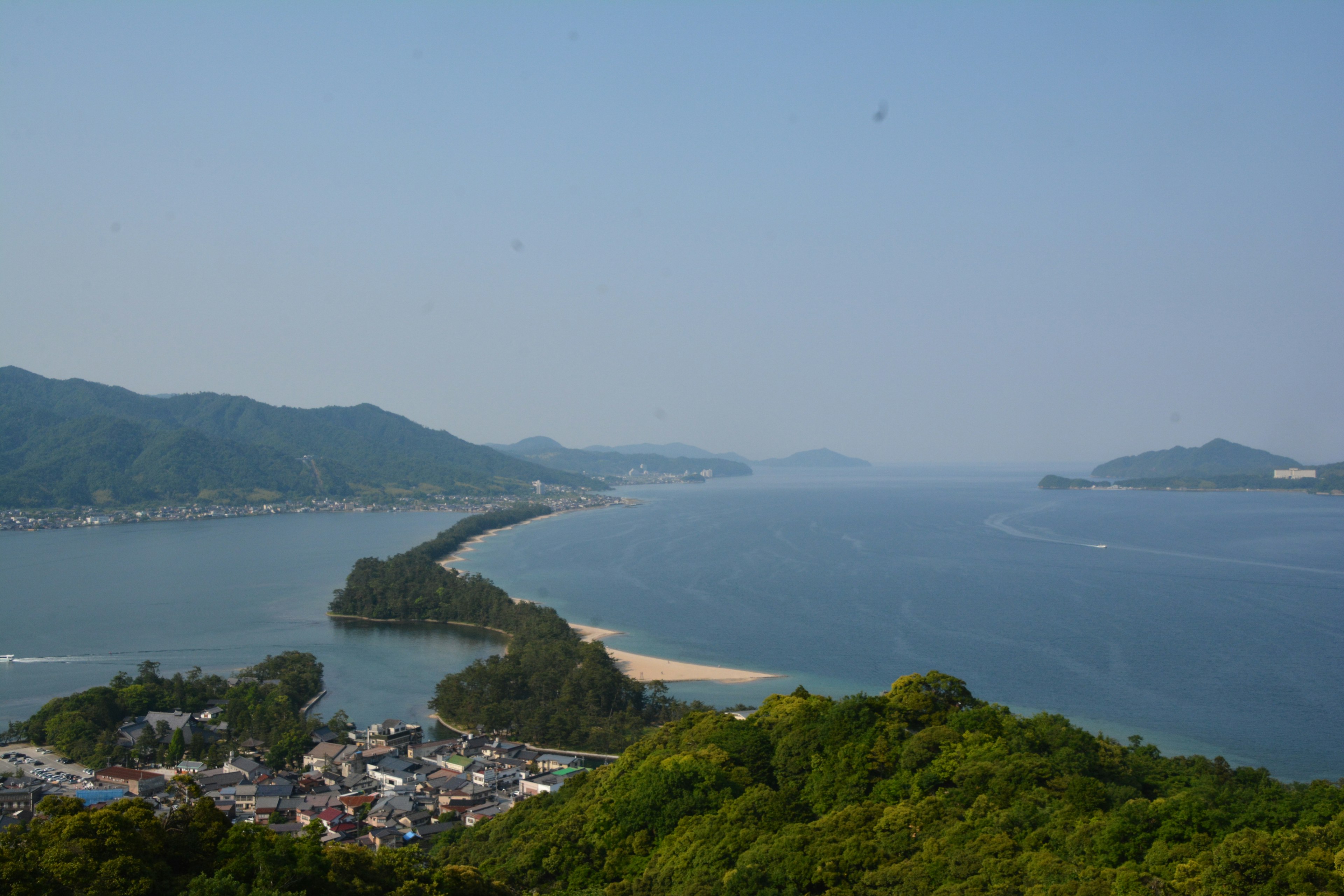 Pemandangan pantai yang indah dengan pegunungan dan desa kecil