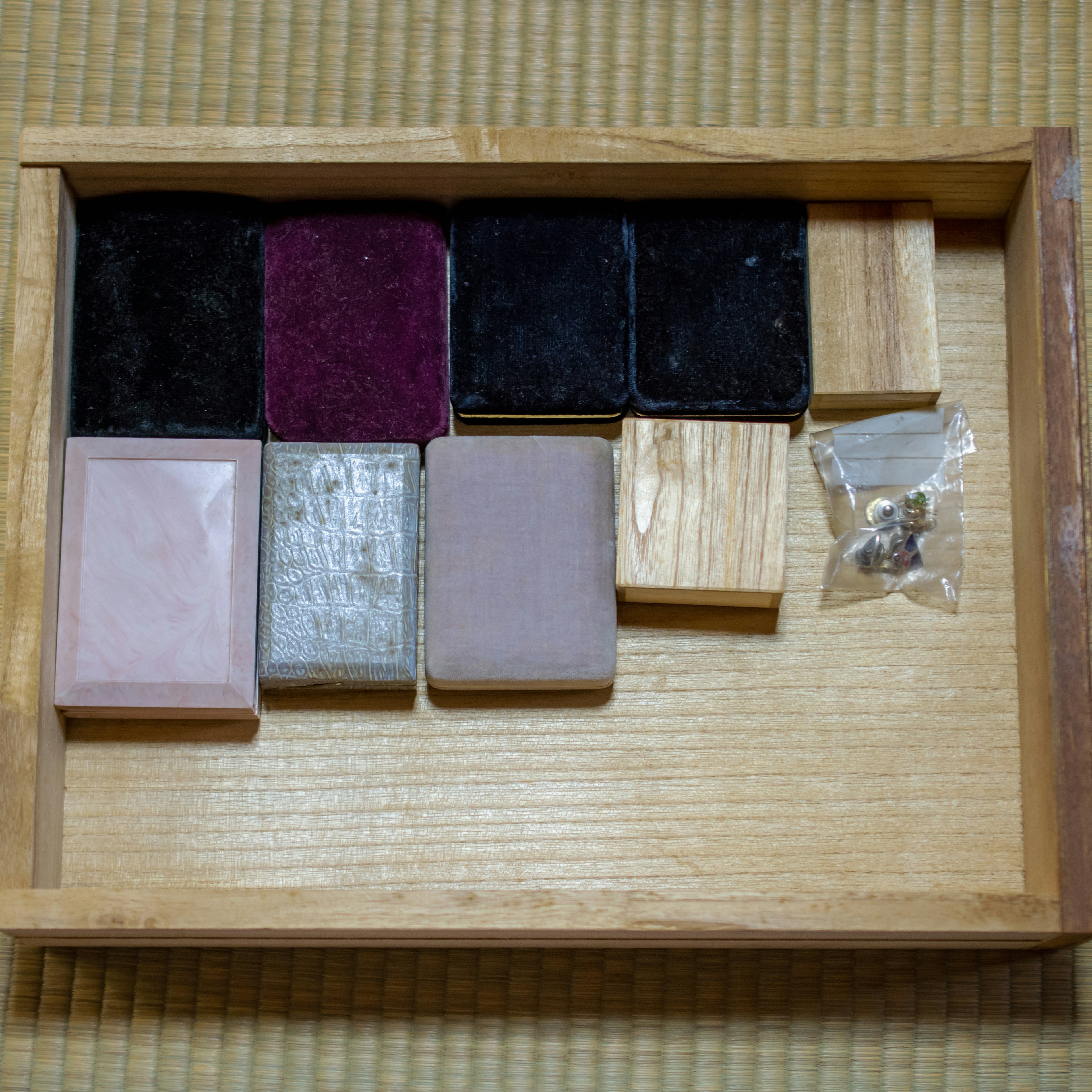 A wooden box containing various colored blocks and a transparent bag