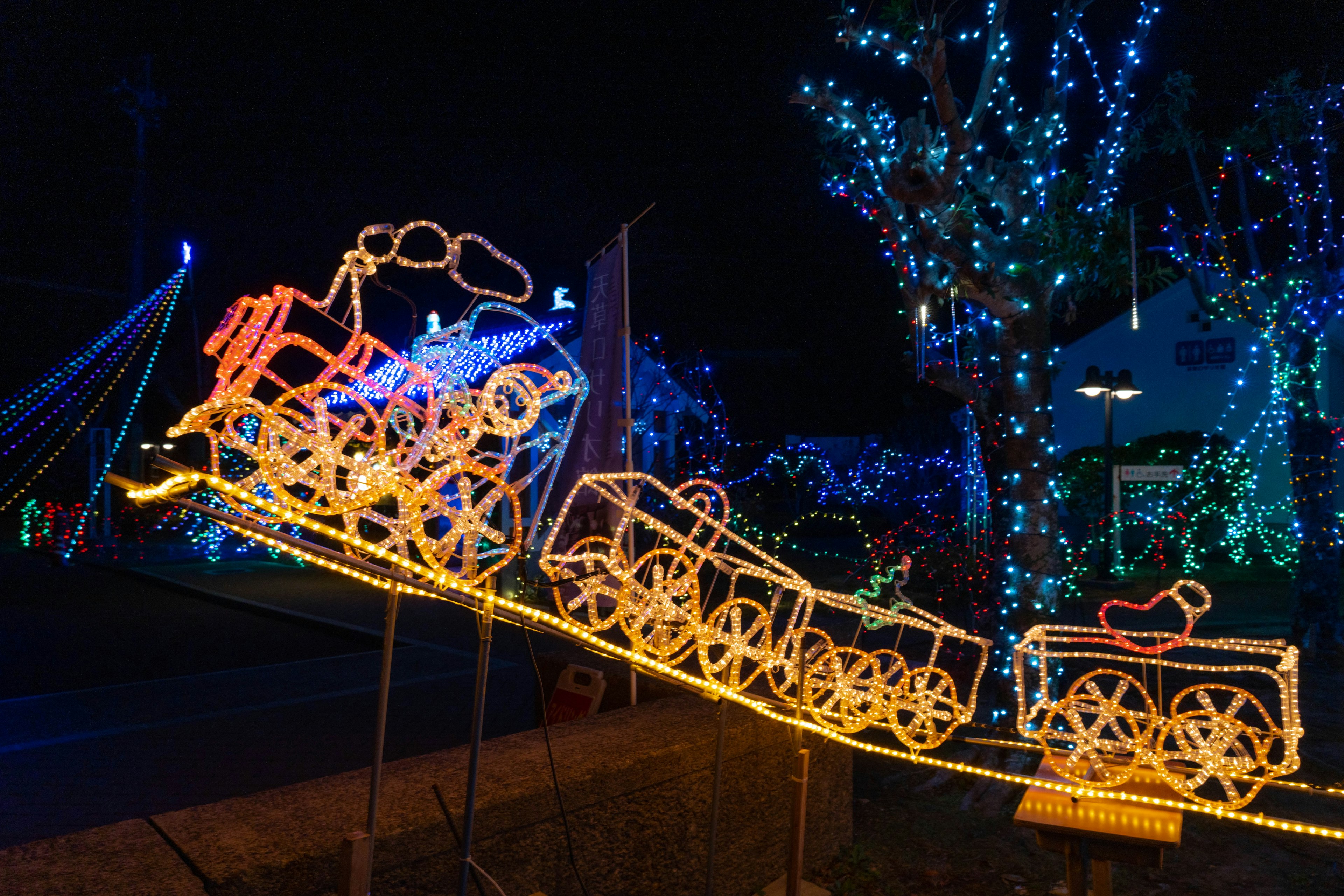 Un train décoratif en lumières exposé la nuit