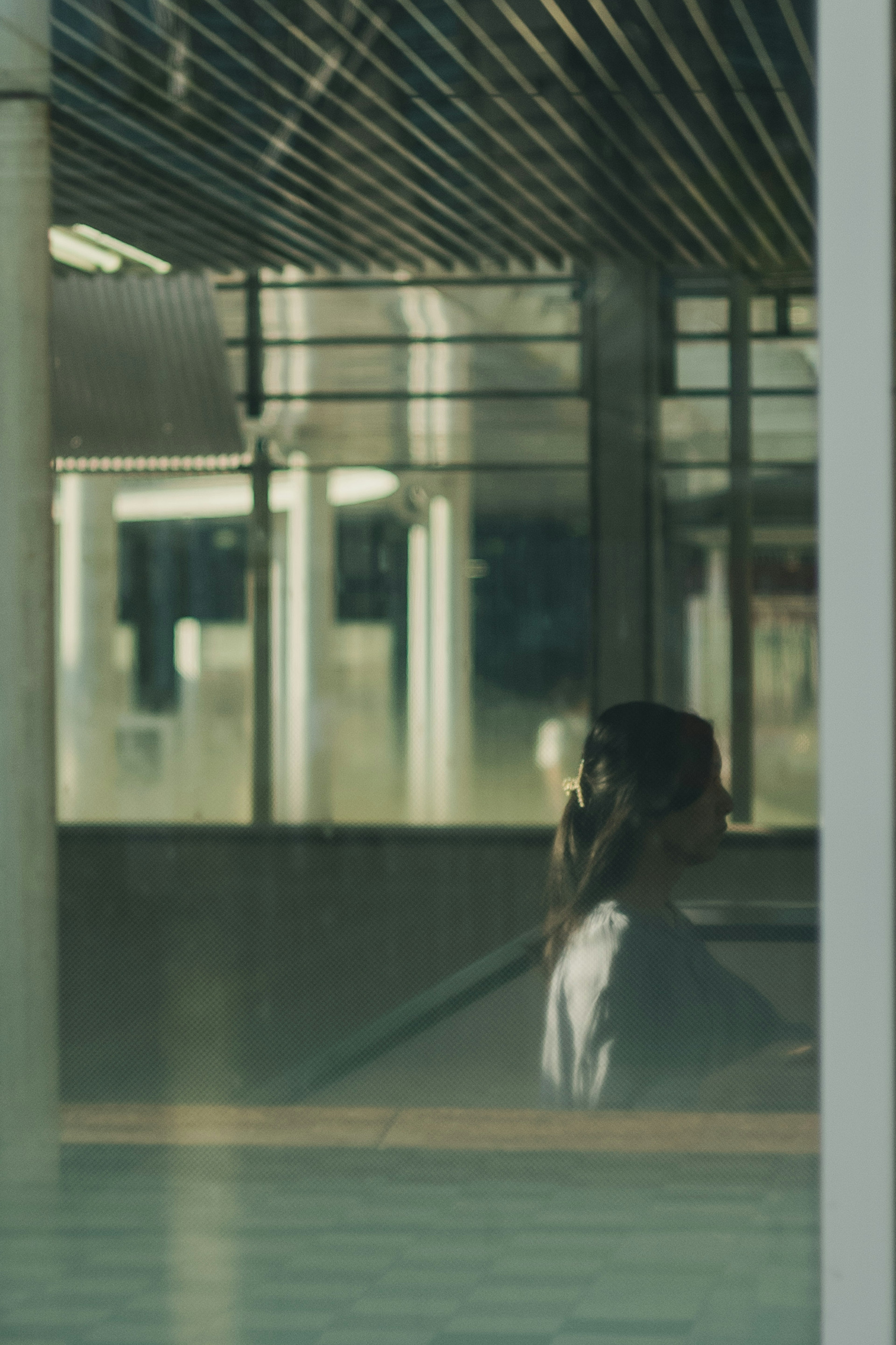 Silhouette einer Frau, die durch ein Fenster mit Lichtreflexionen gesehen wird