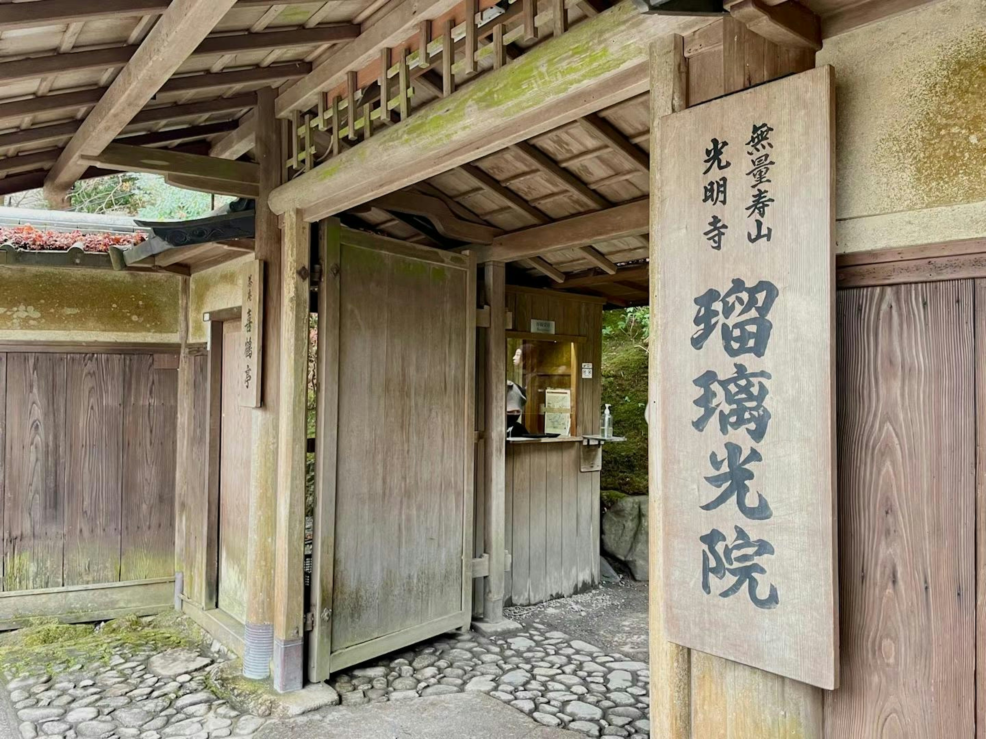 伝統的な日本の寺院の入り口である瑠璃光院の看板が見える