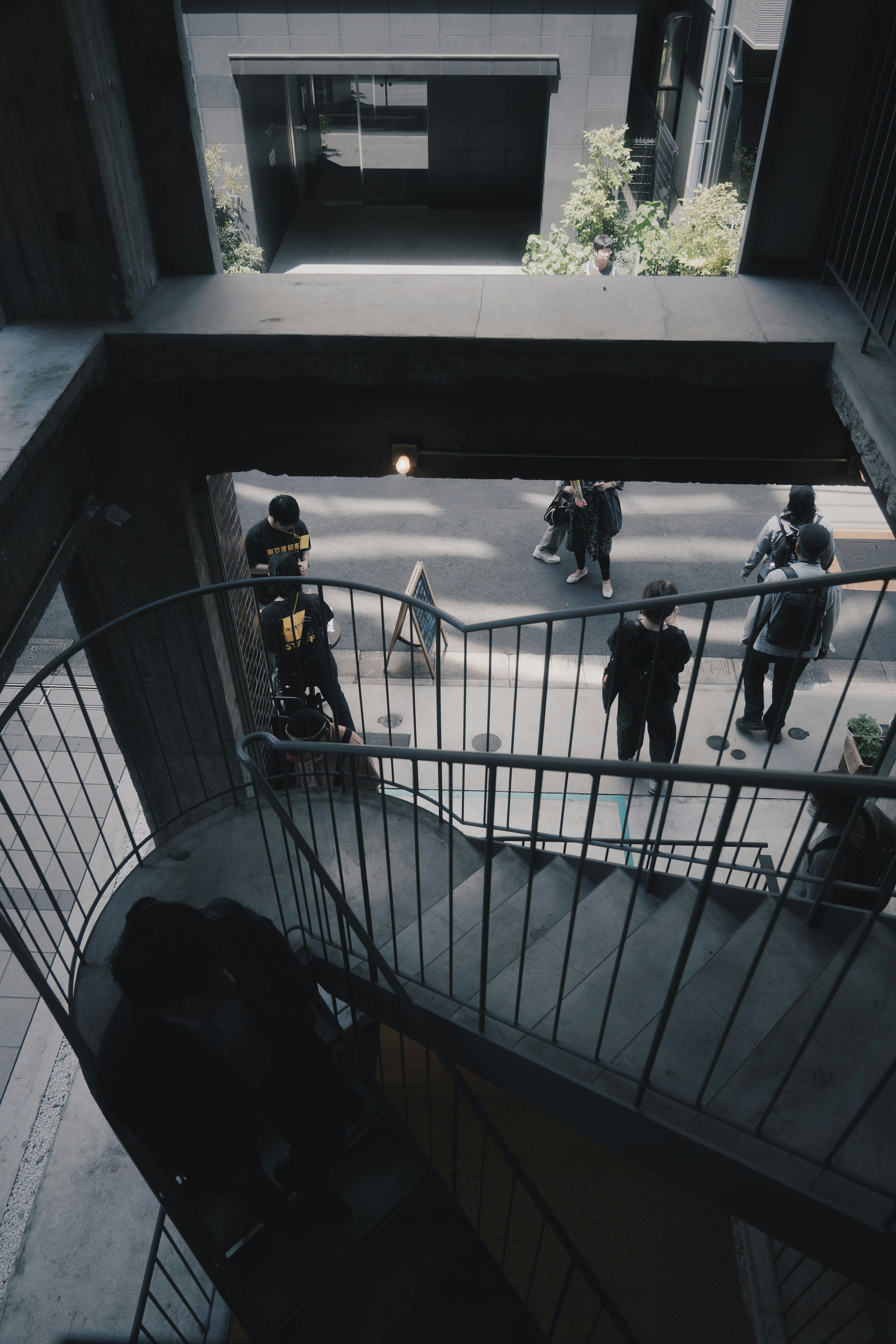 Vista di una scena di strada dall'alto di una scala a chiocciola Persone che camminano sotto