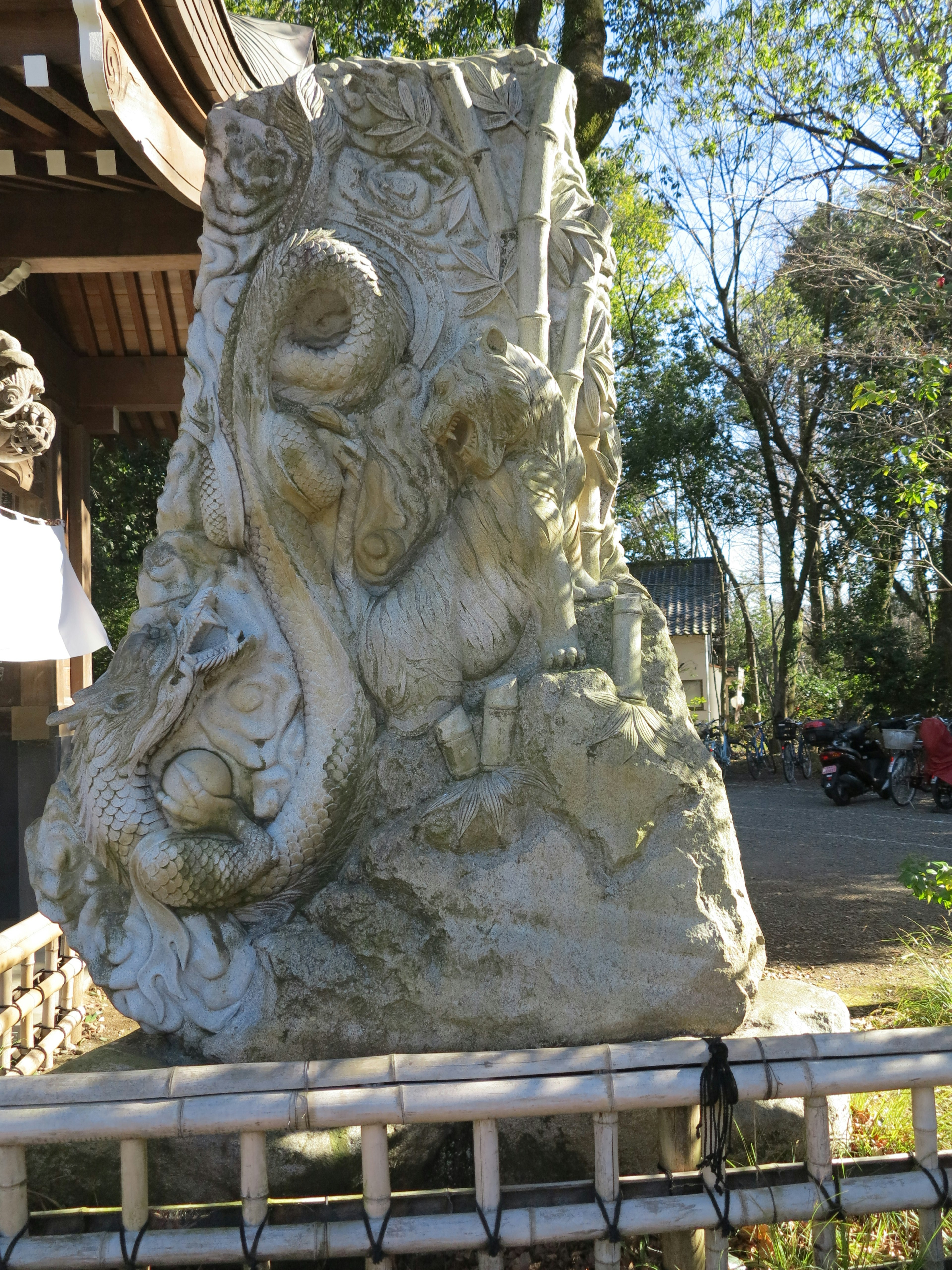 Steinskulptur mit einer Figur und Tieren umgeben von Natur