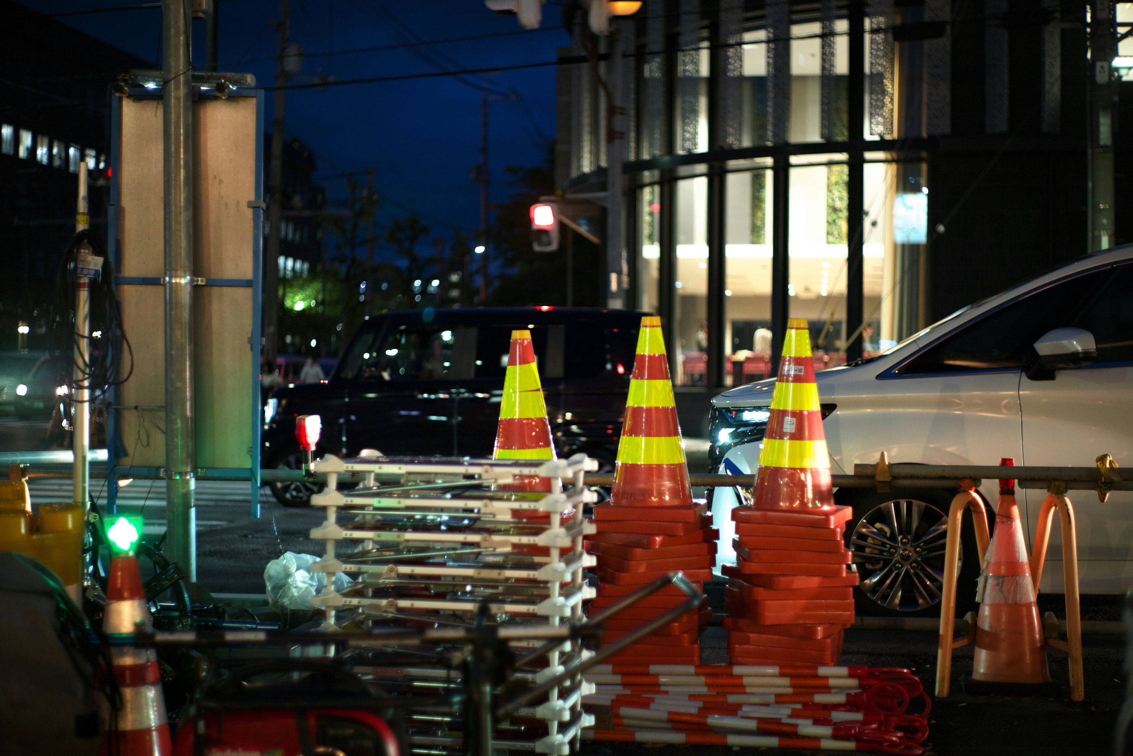 夜の街角に立つ交通コーンと工事用バリケード