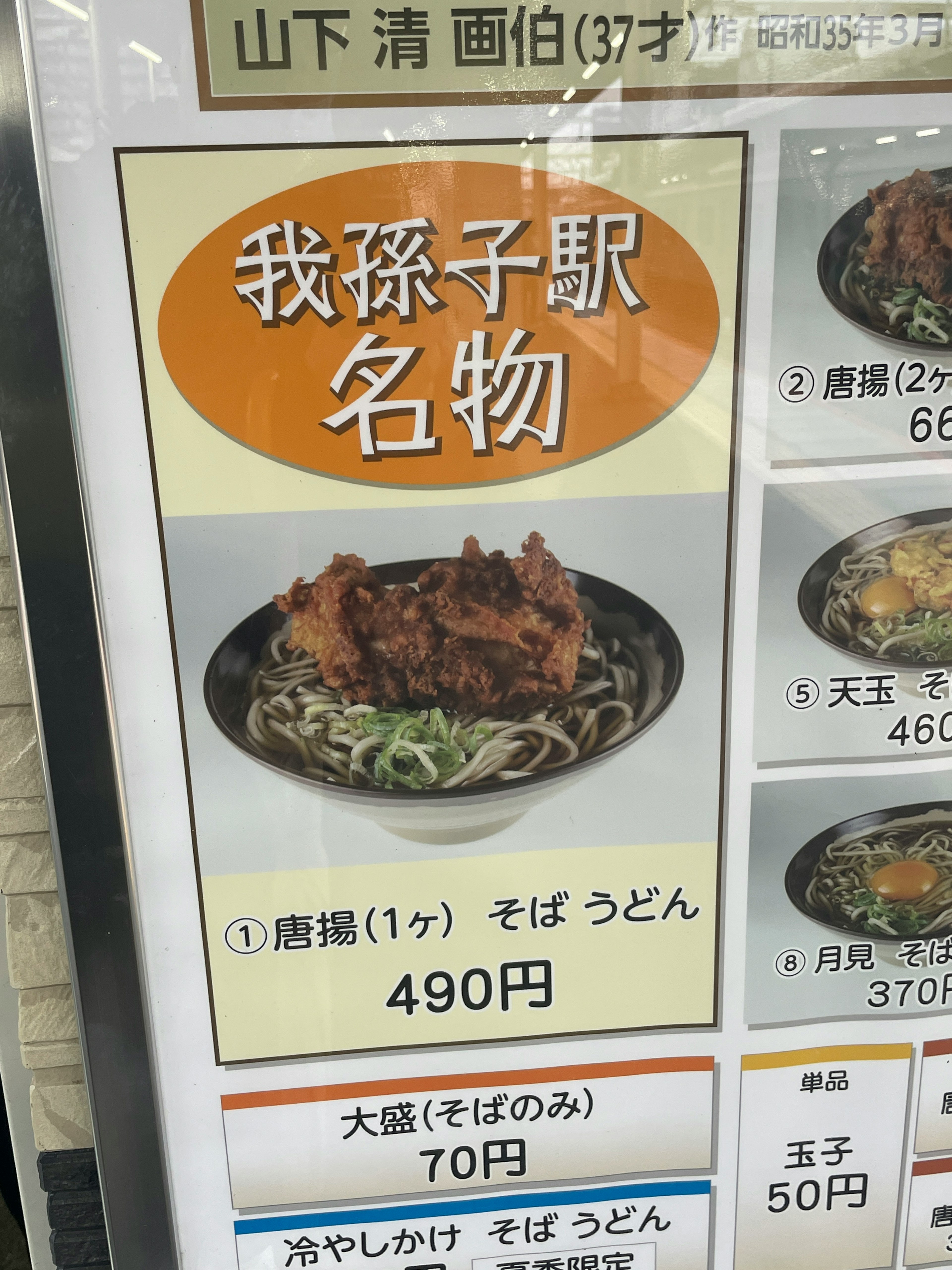 Gambar papan menu yang menampilkan hidangan terkenal dari Yamashita Kiyoshi termasuk ayam goreng dan soba udon