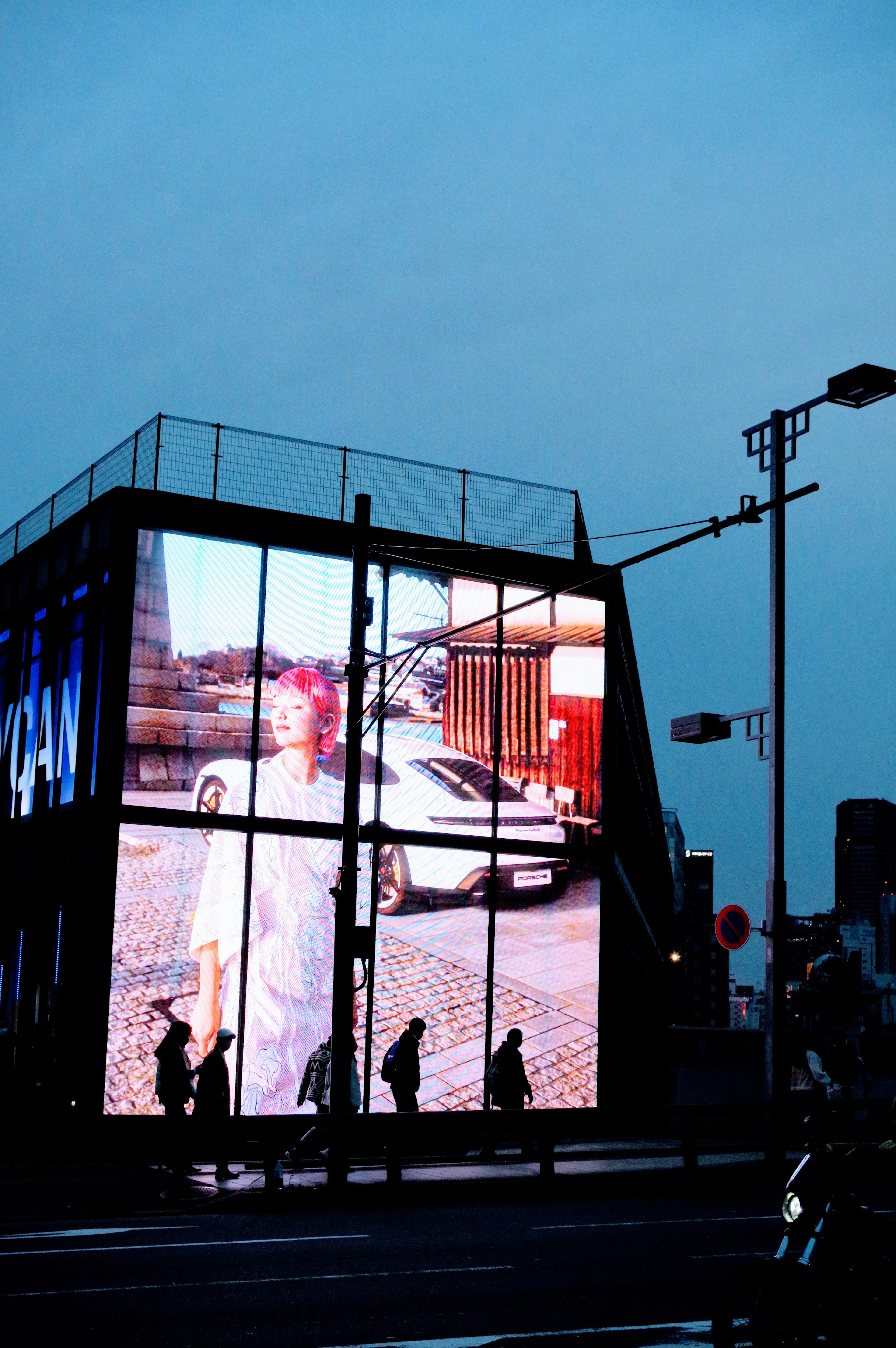 Large digital display featuring a person and urban scenery under a blue sky