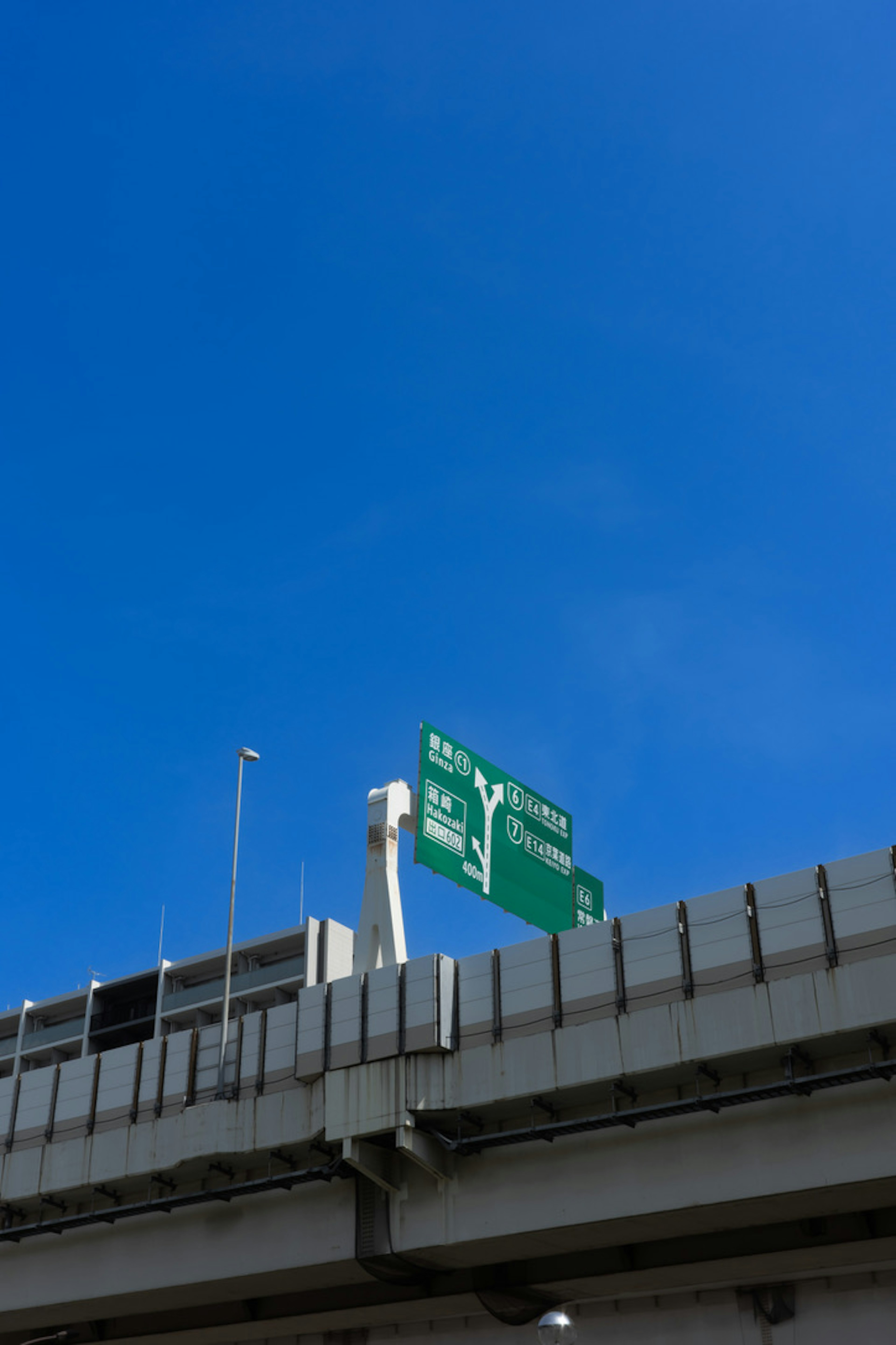 Verkehrsschild und Teil einer Brücke unter klarem blauen Himmel