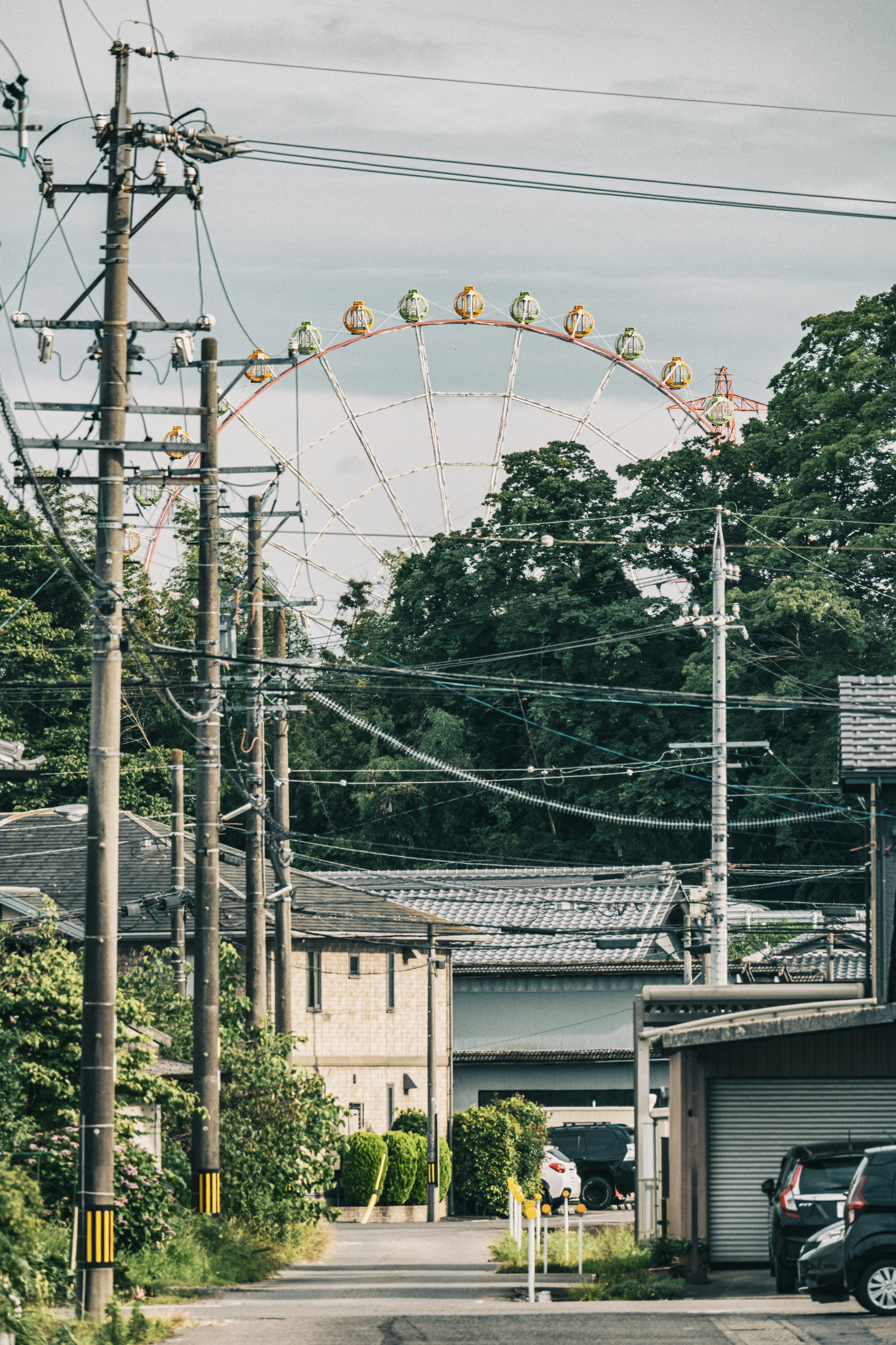 電柱と住宅の間に見える観覧車の風景