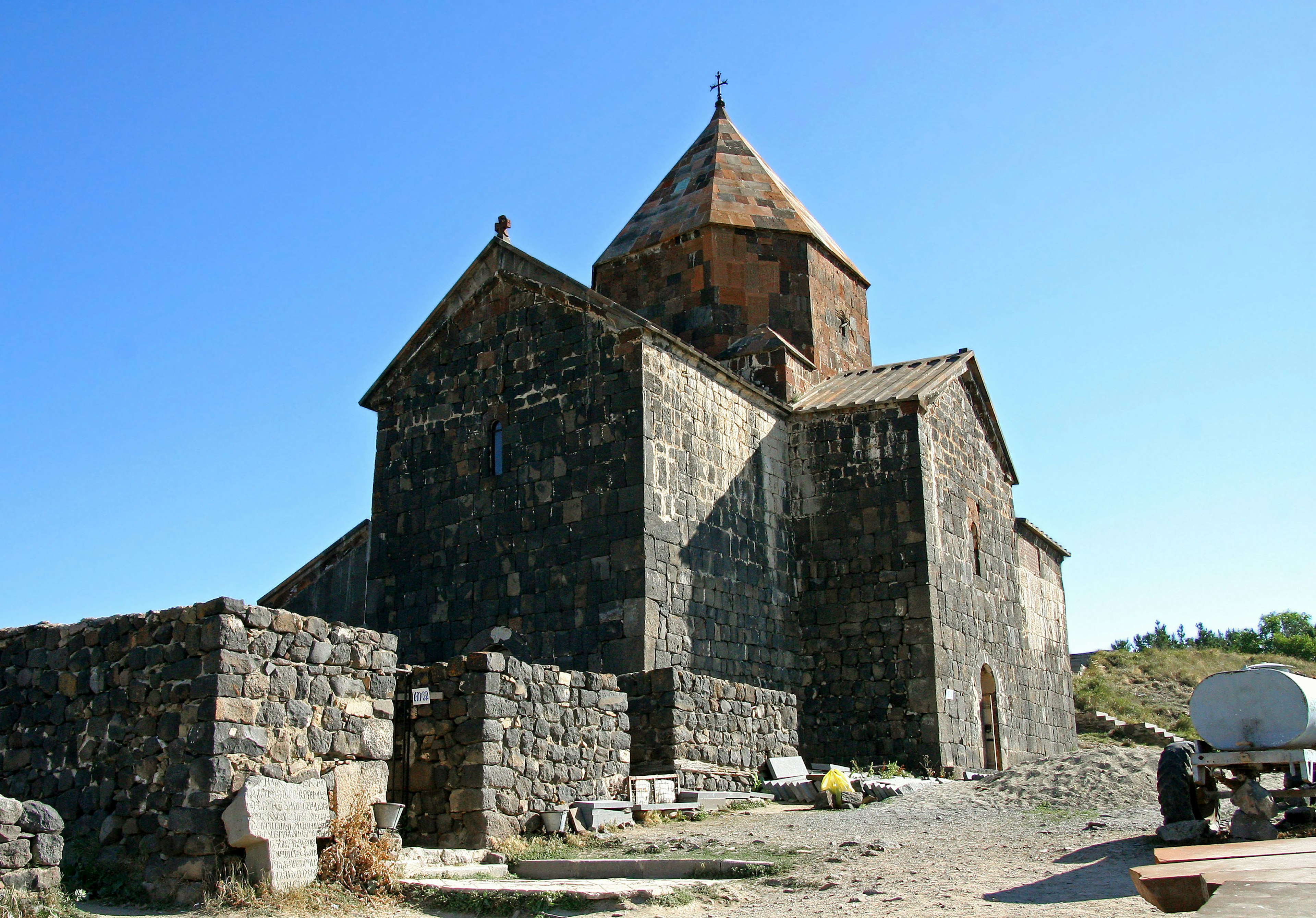 Extérieur d'une ancienne église en pierre sous un ciel bleu clair