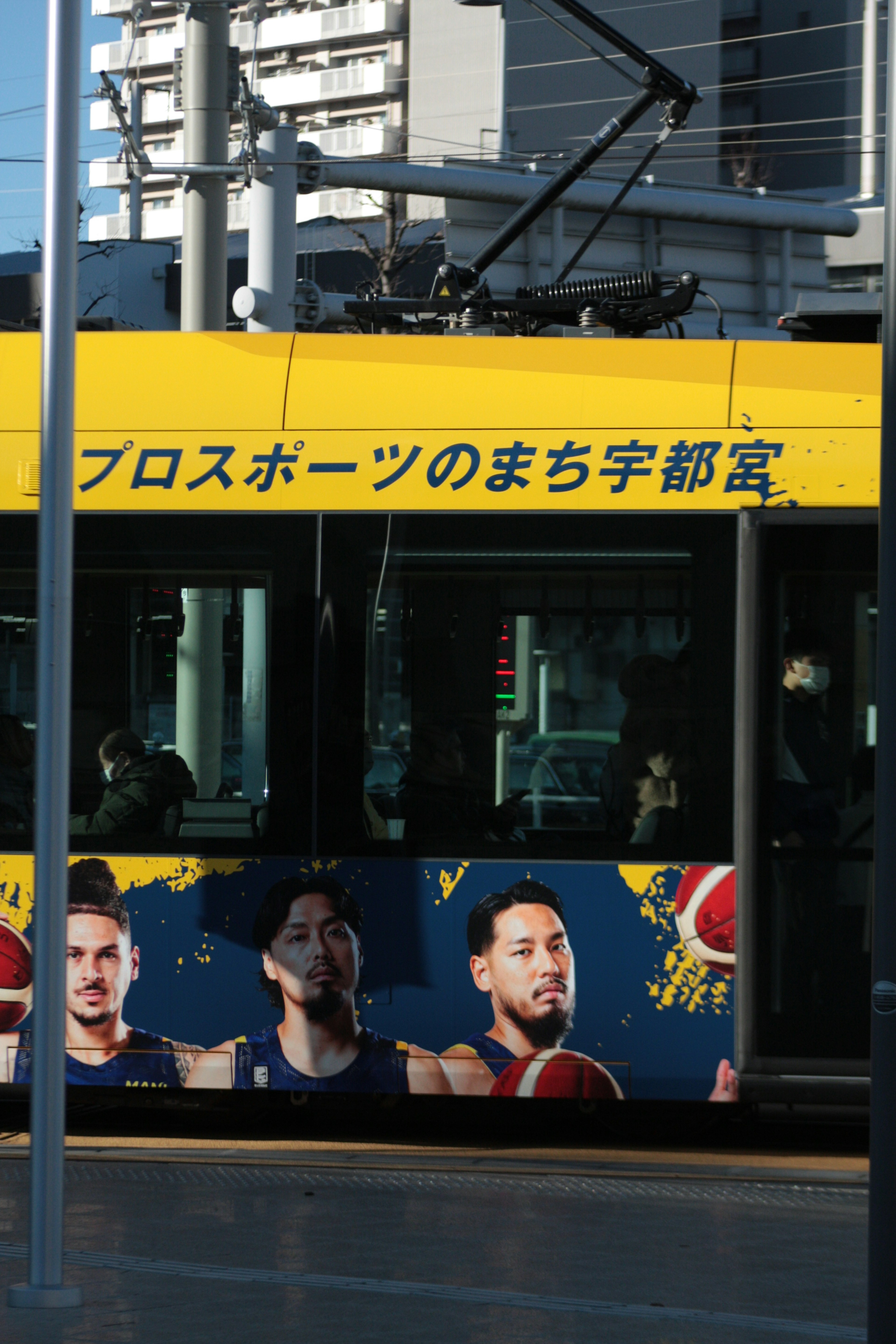 Pubblicità sul lato di un autobus con giocatori di basket design giallo brillante e tema sportivo