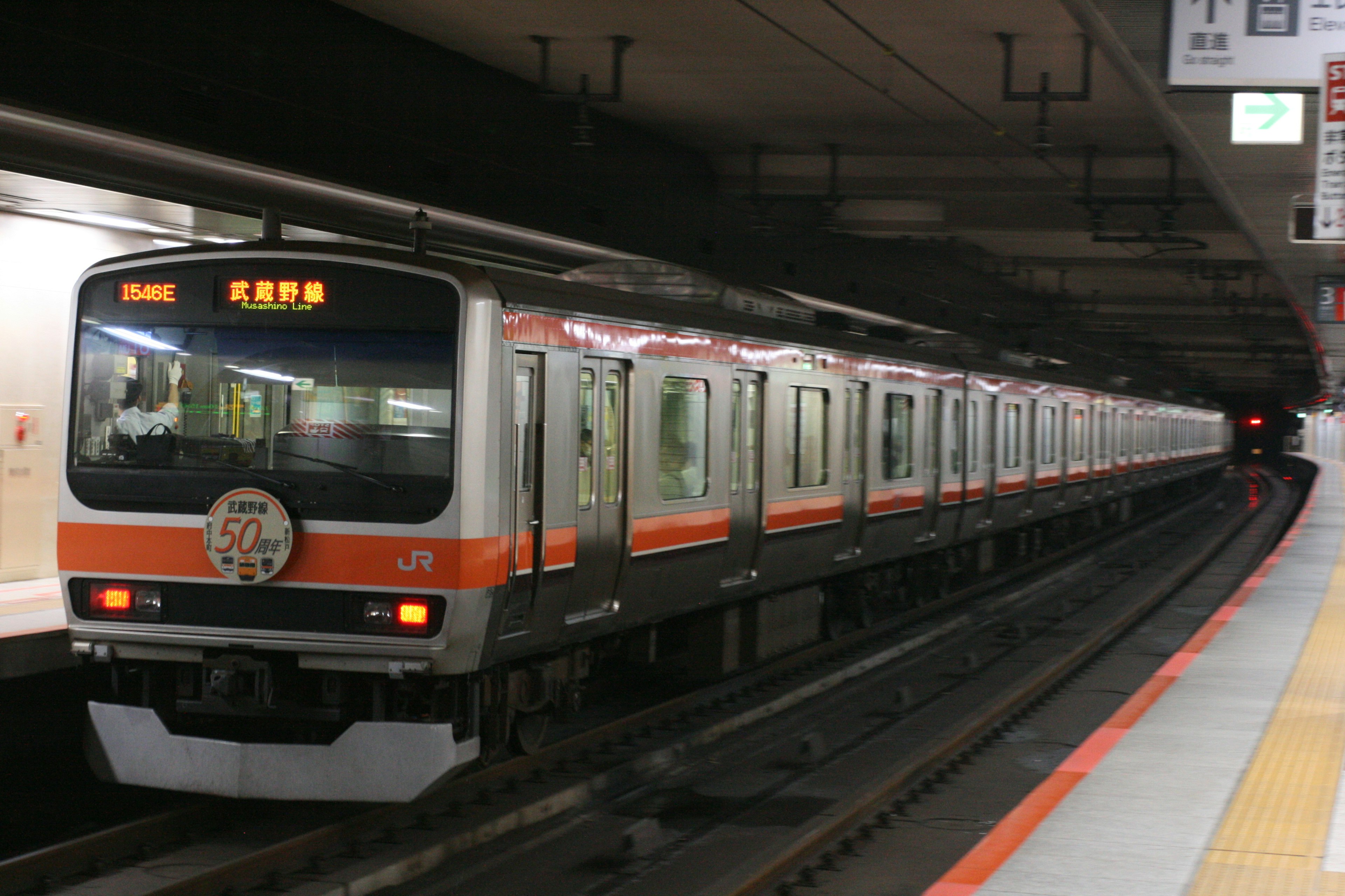 地下鉄の駅に停車中のオレンジと白の電車